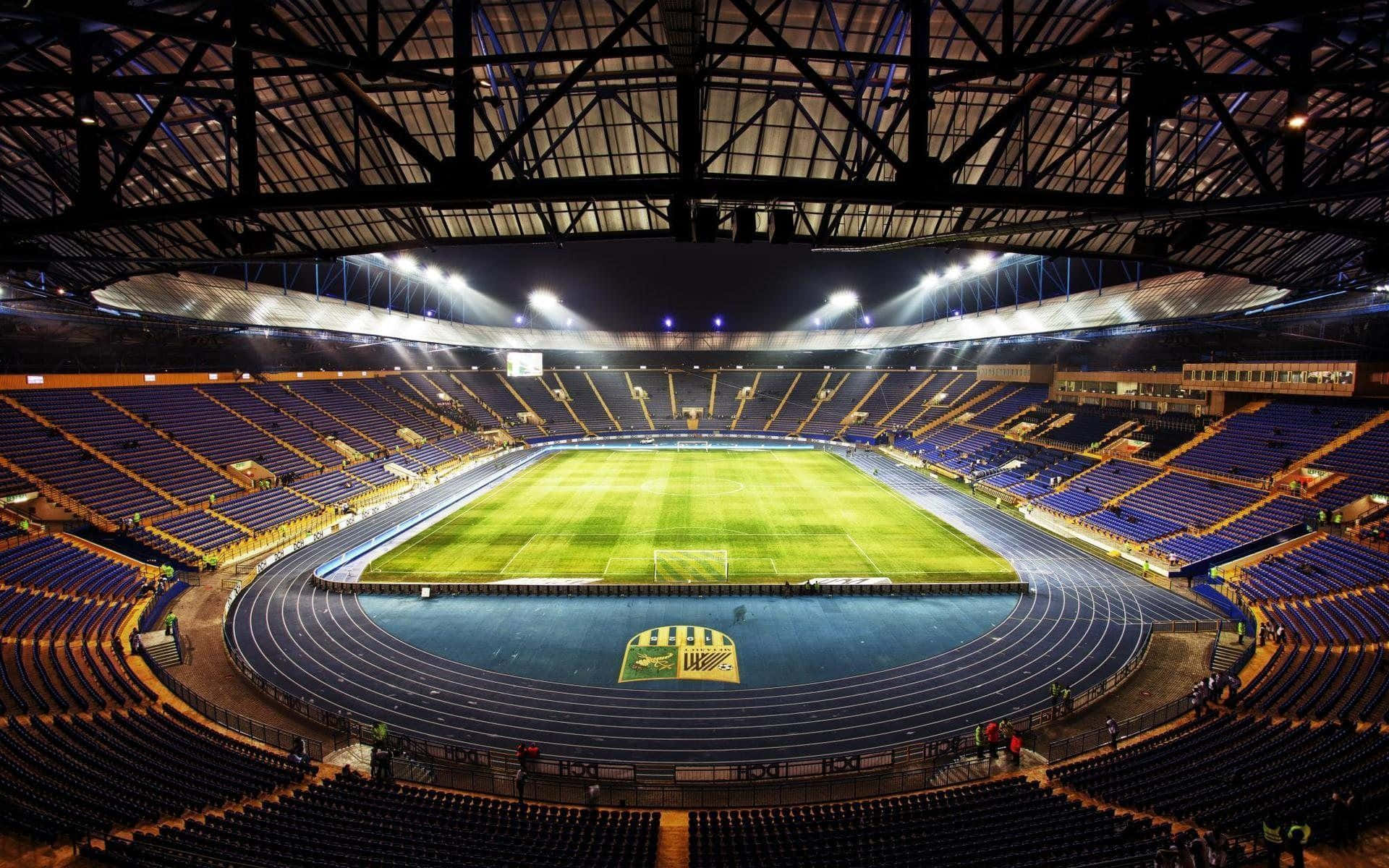 A Soccer Field With Blue Seats Background