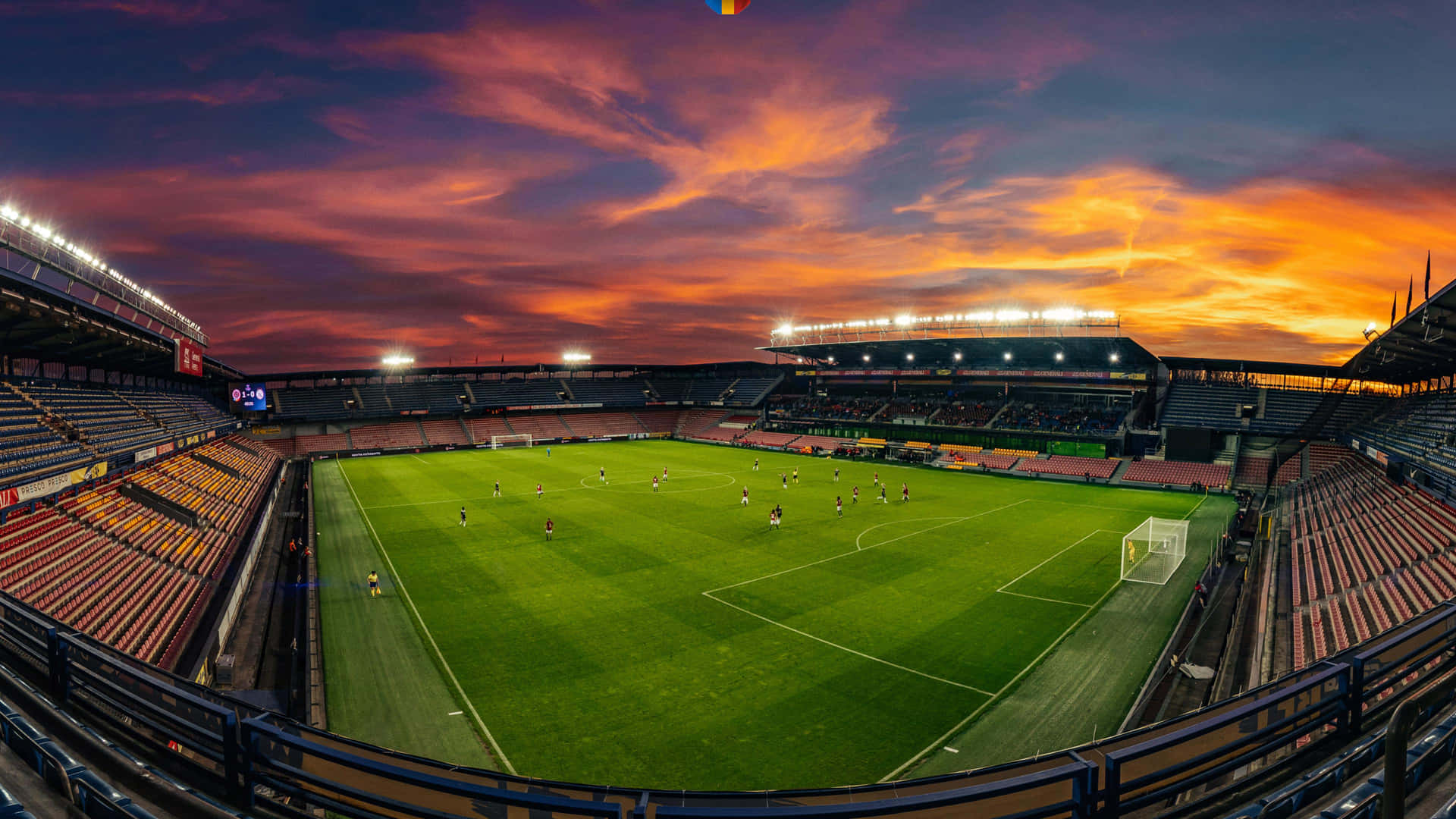 A Soccer Stadium With A Sunset Sky