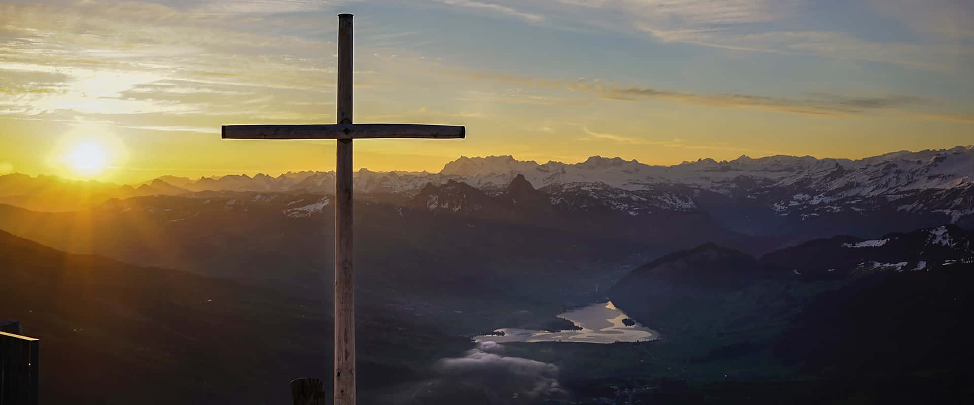 A Soft, Colorful Crucifix Against A Vibrant Sky Background