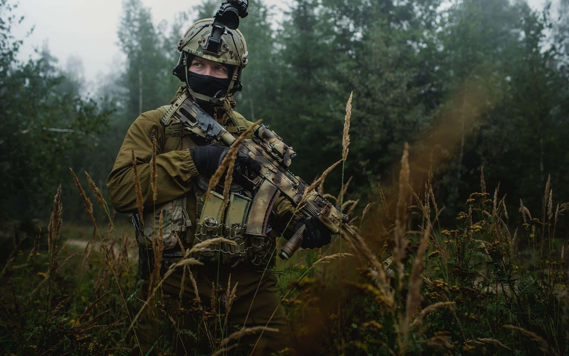 A Soldier In A Military Uniform Is Standing In The Field Background