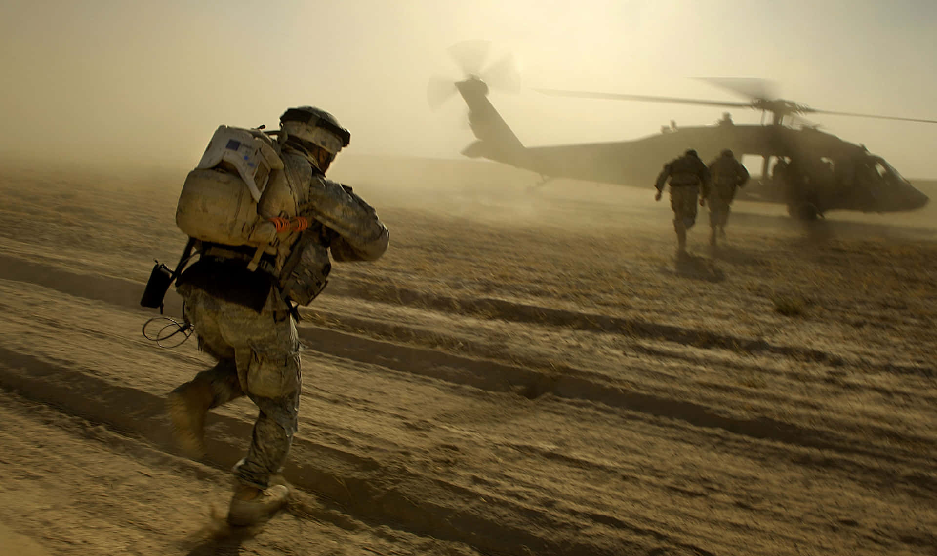 A Soldier Is Running Towards A Helicopter Background