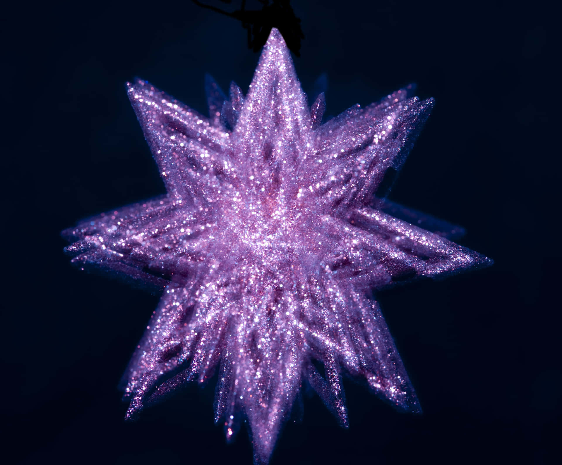 A Sparkling Purple Star Shining Against A Starry Night Sky Background