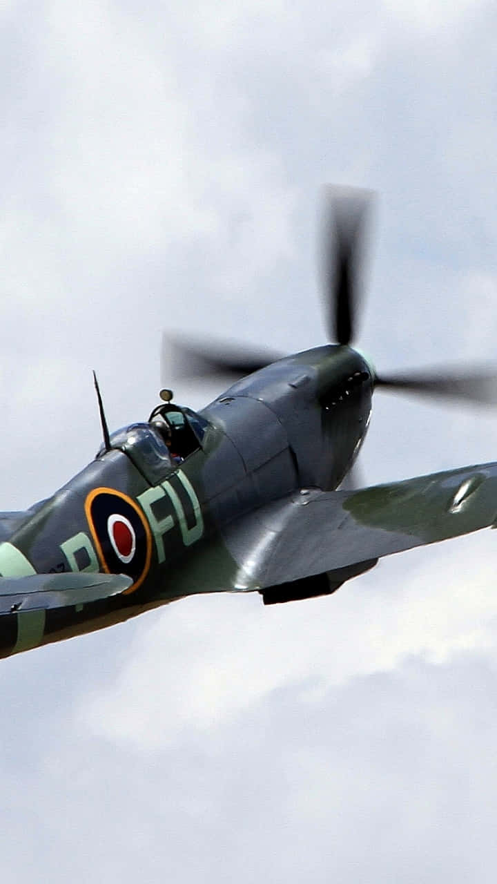 A Spitfire Aircraft Flying Over The Sea Background