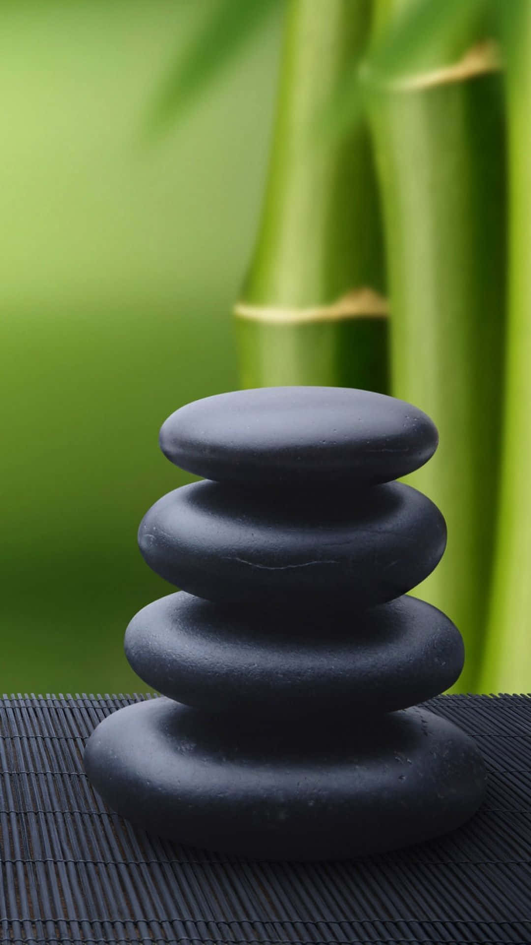 A Stack Of Black Stones On A Bamboo Mat