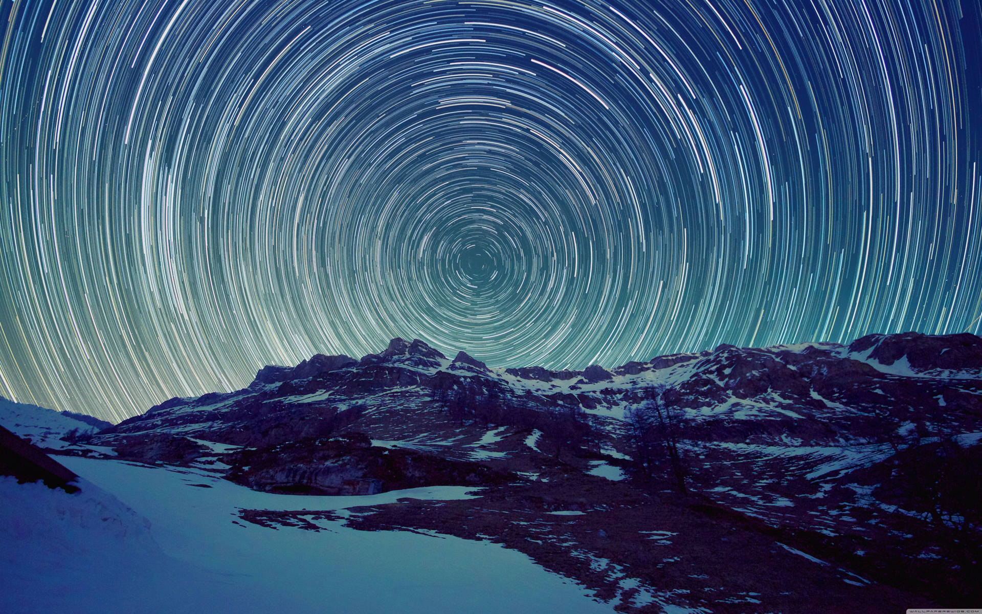 A Star Trail Over A Mountain Range Background