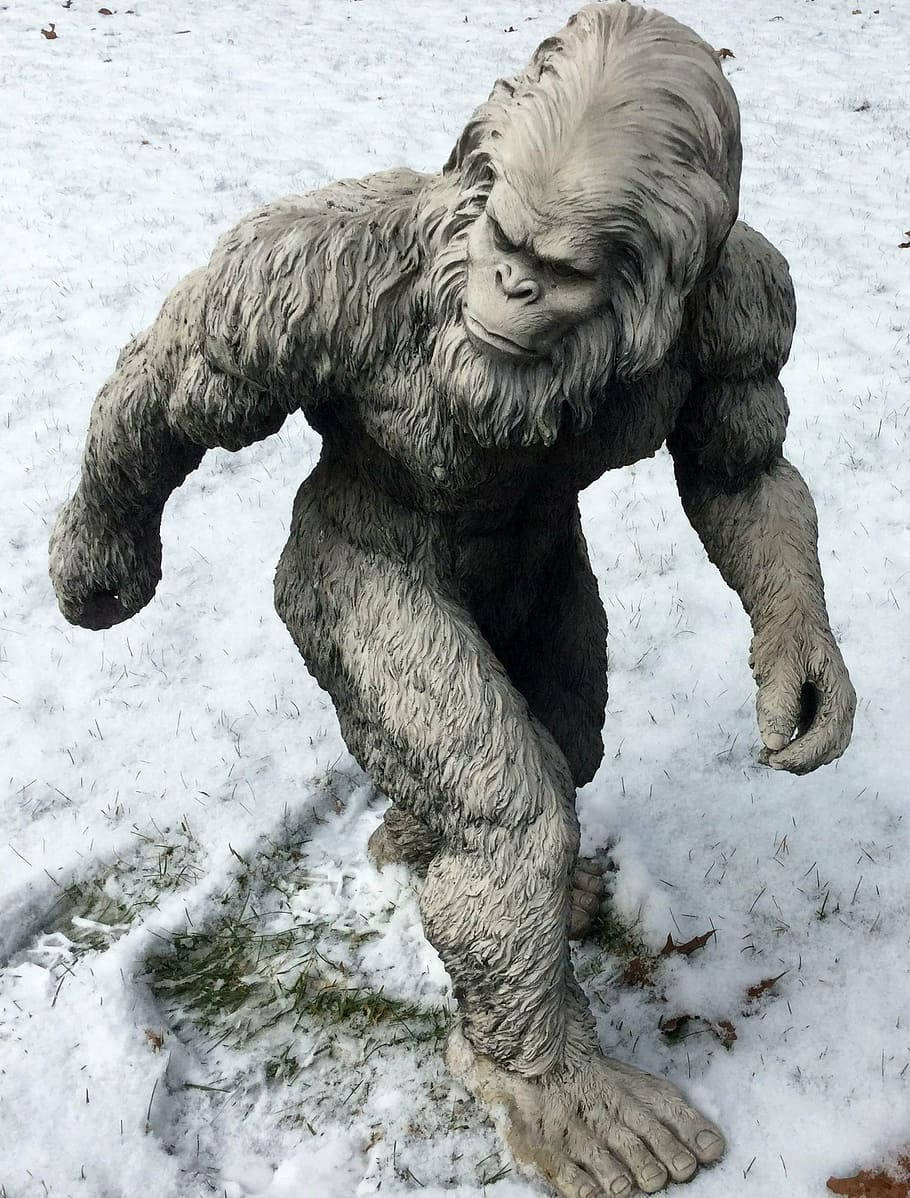 A Statue Of A Bigfoot In The Snow Background