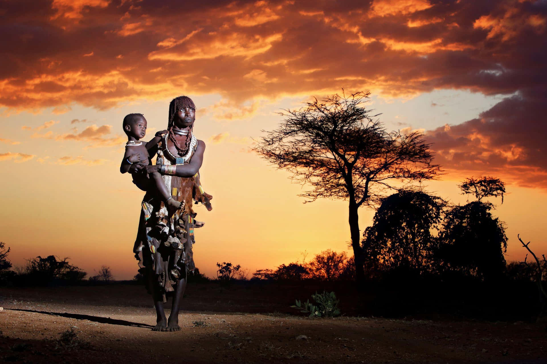 A Statue Of A Woman And Child Standing In The Desert Background