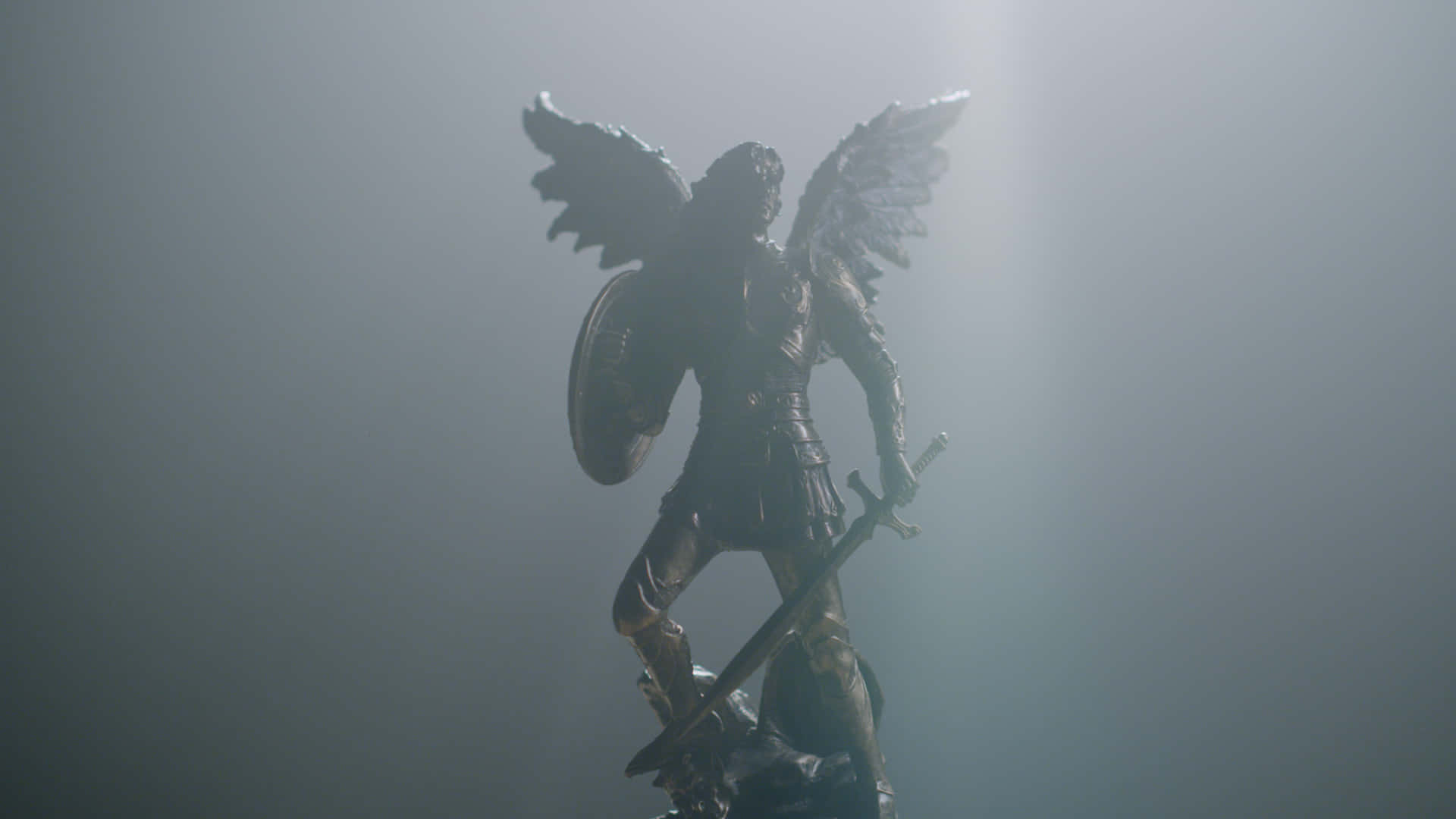A Statue Of An Angel With A Shield In The Light Background
