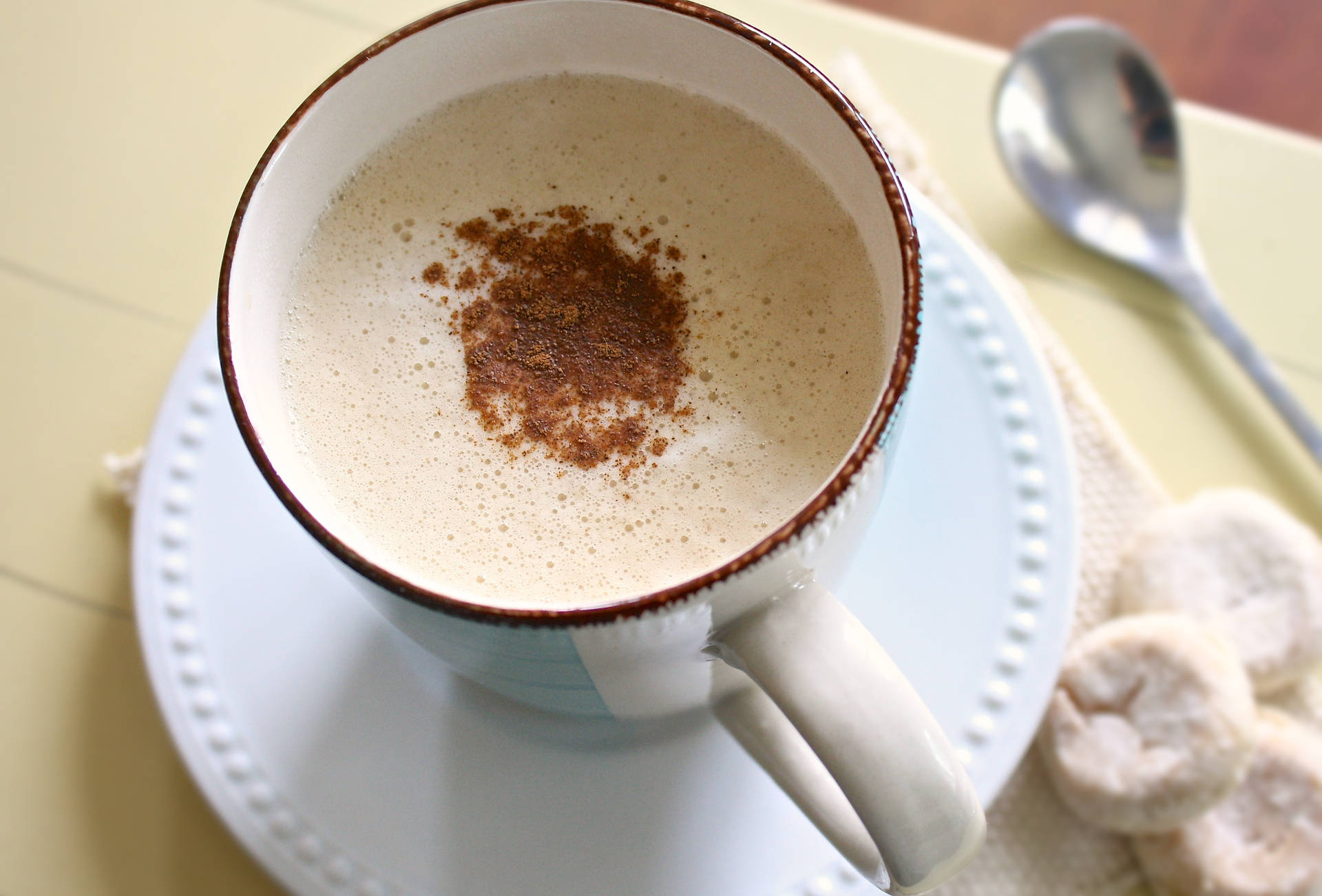A Steaming Cup Of Freshly Brewed Cinnamon-flavored Coffee With A Creamy Layer Of Foam Background