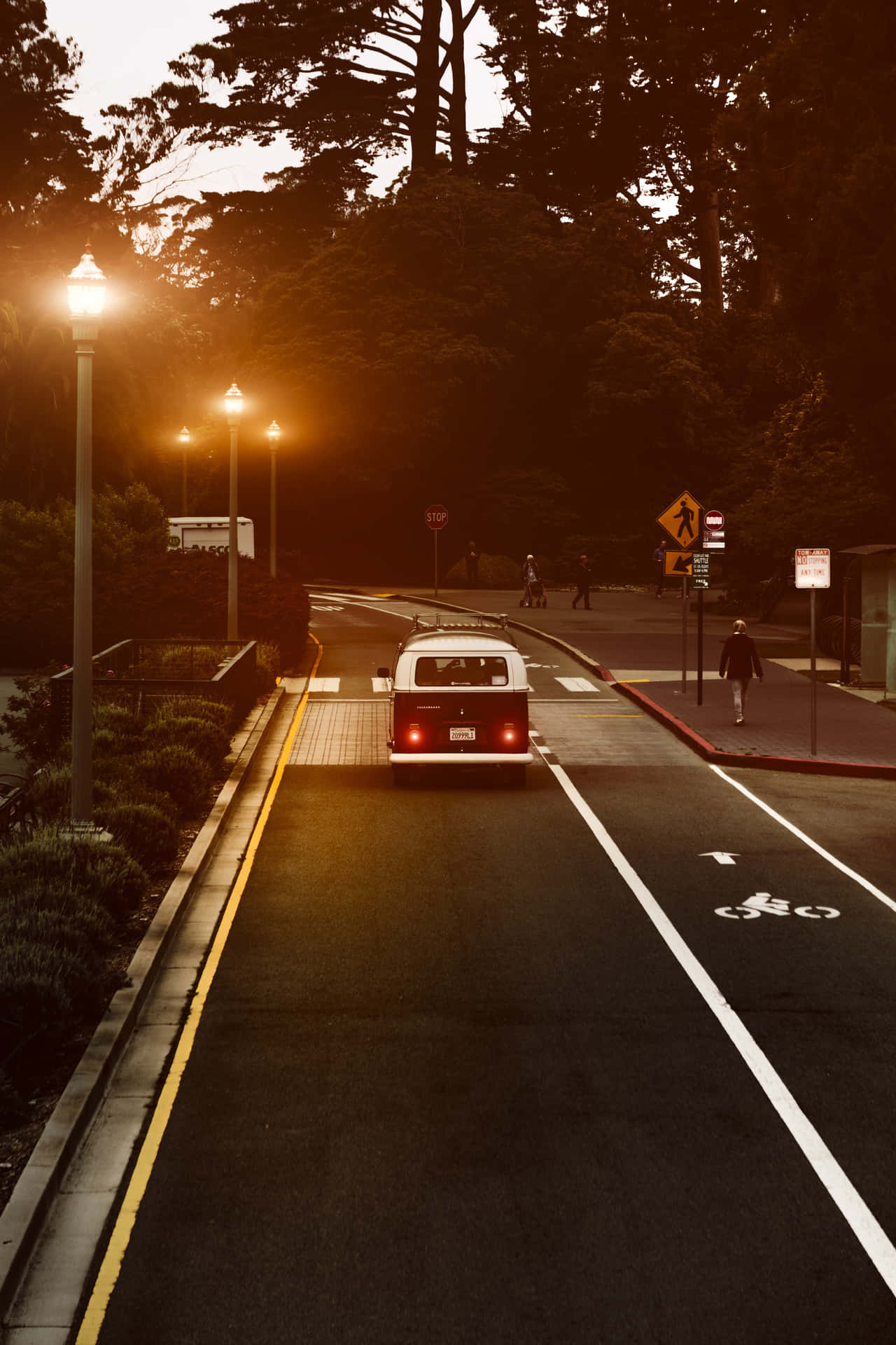 A Street With A Car Driving Down It