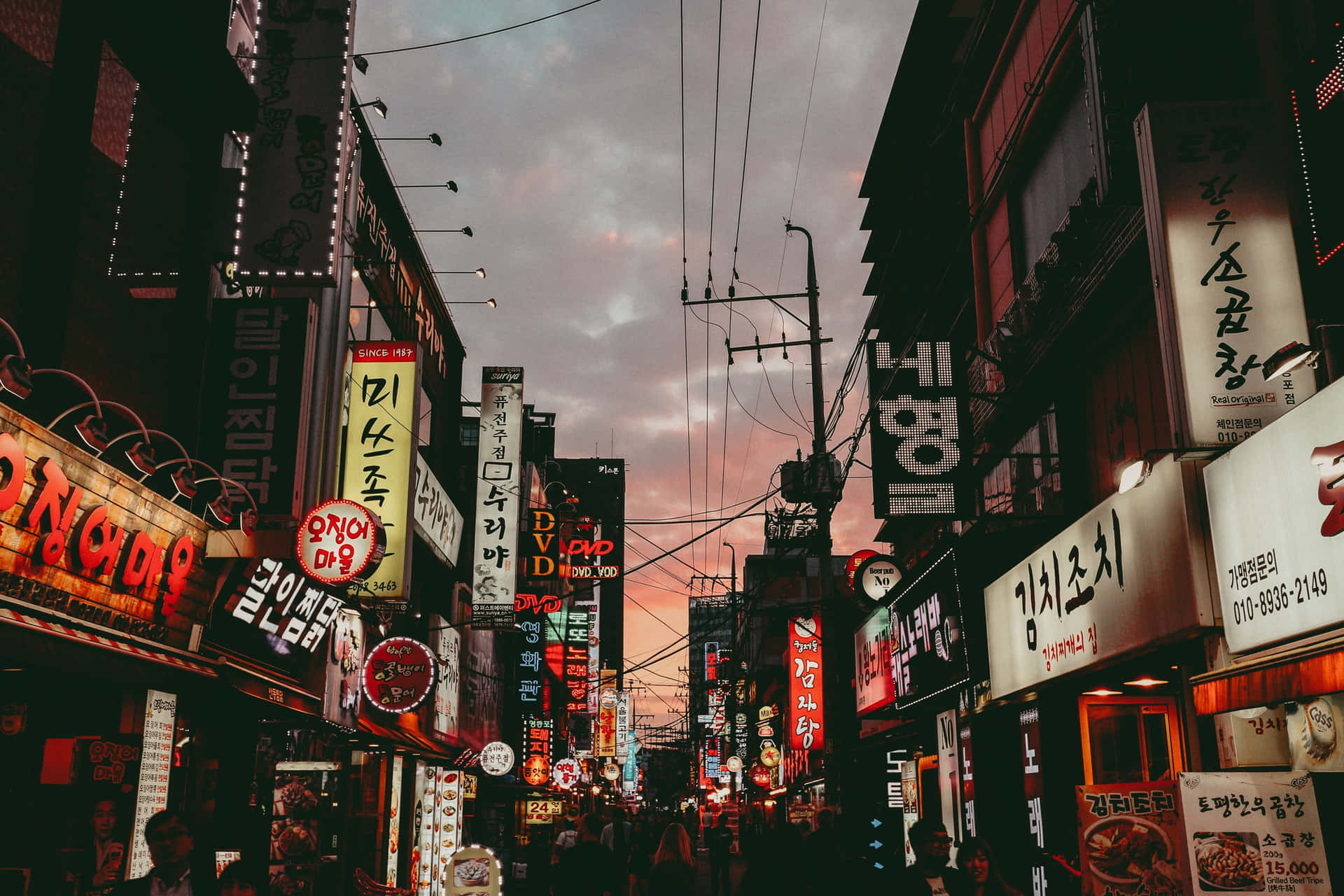 A Street With Many Signs Background