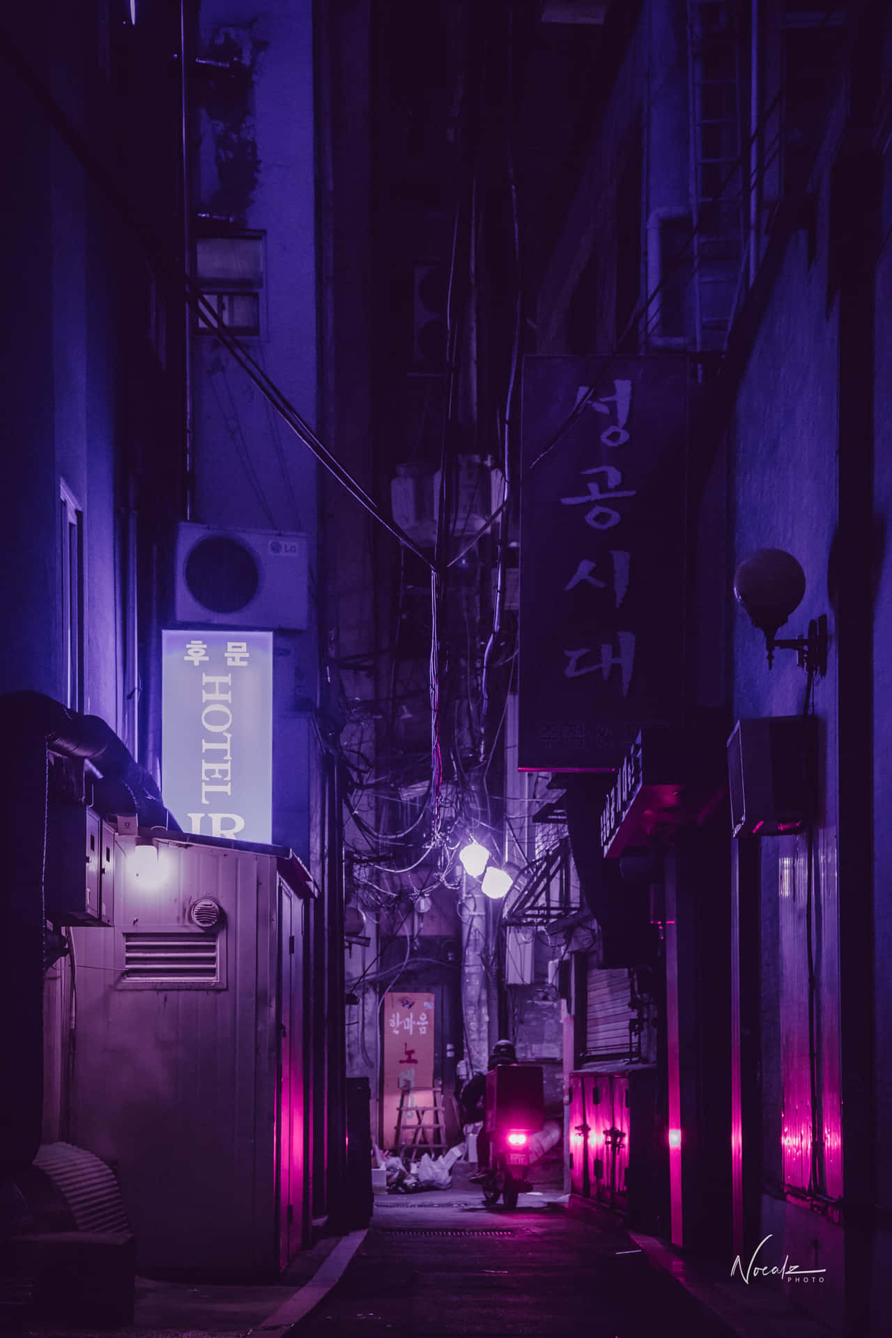 A Street With Neon Lights And A Bike Background