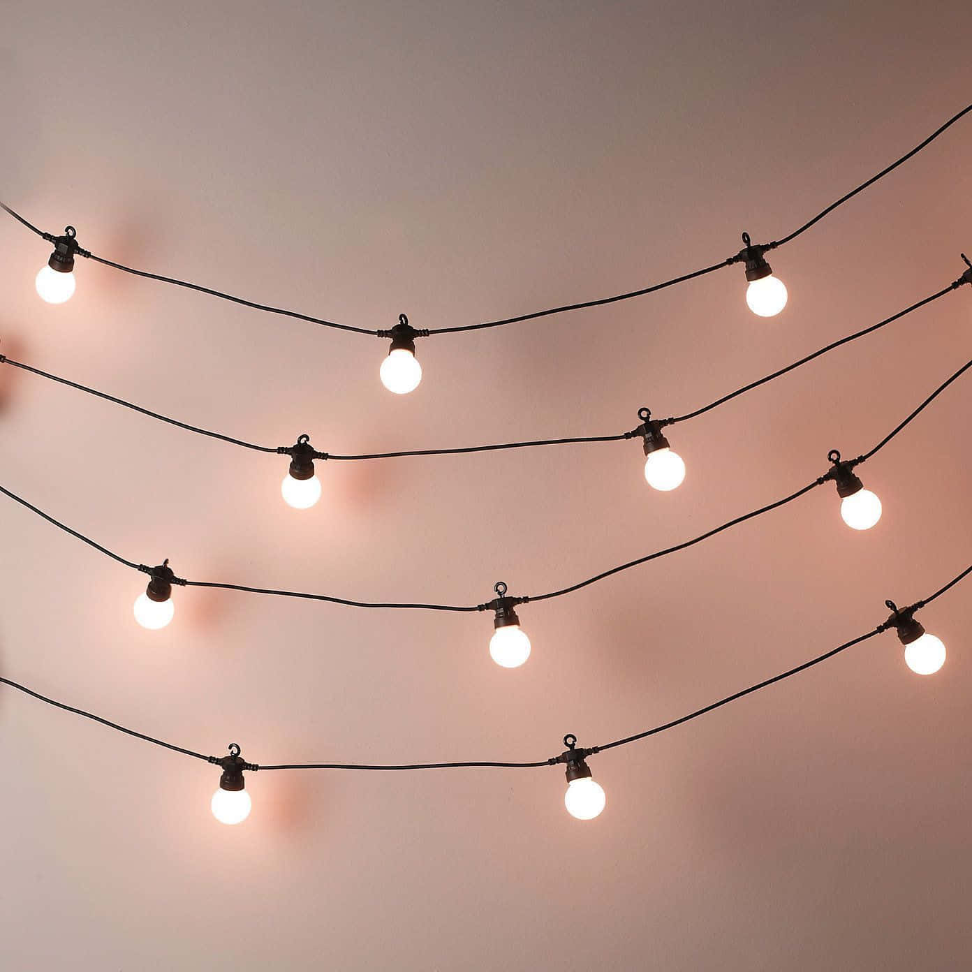 A String Of Lights With A Pink Bulb Background
