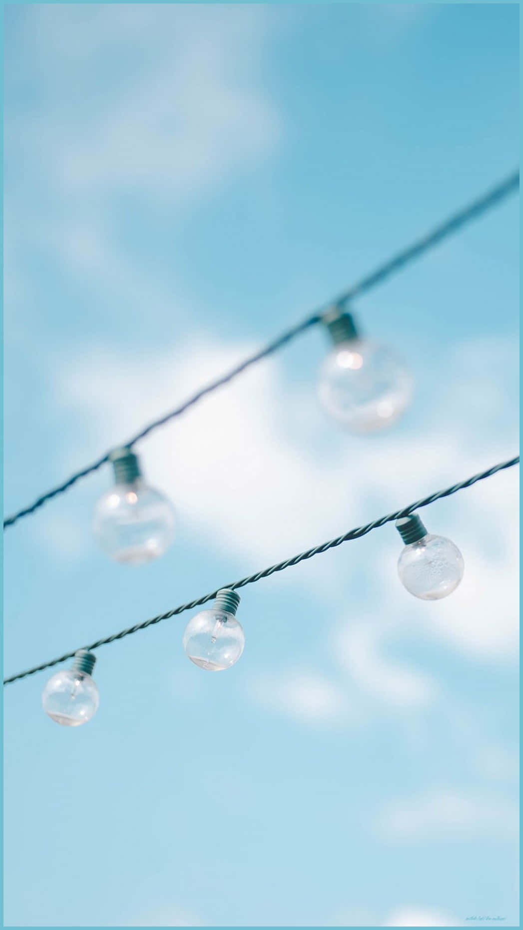 A String Of Lights With Blue Sky Behind Them Background