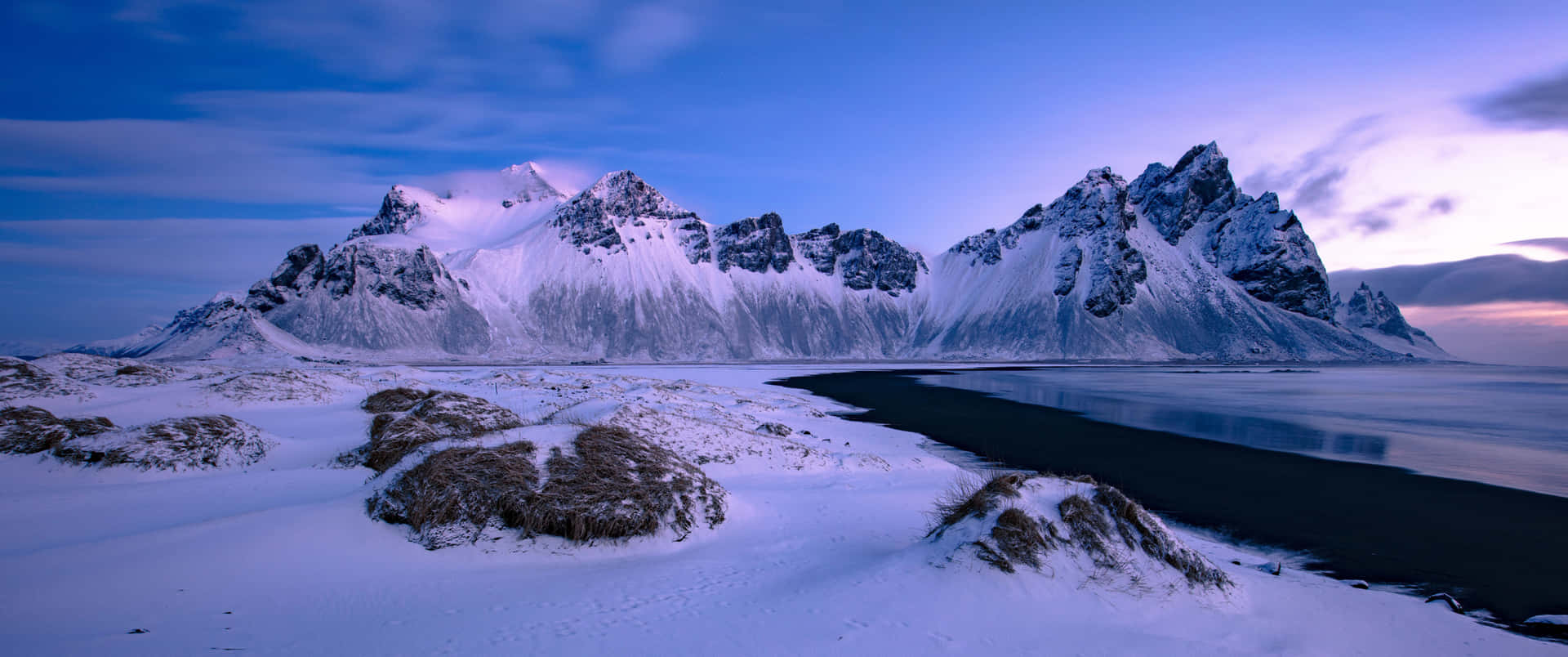 A Stunning Winter Scene Of Snow-covered Evergreen Trees And A Tranquil Lake. Background