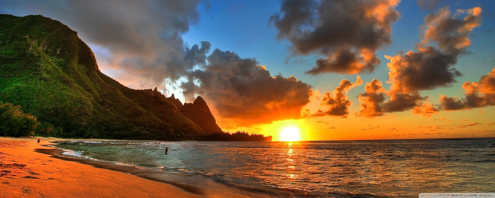 A Sunset Over A Beach With Mountains In The Background Background