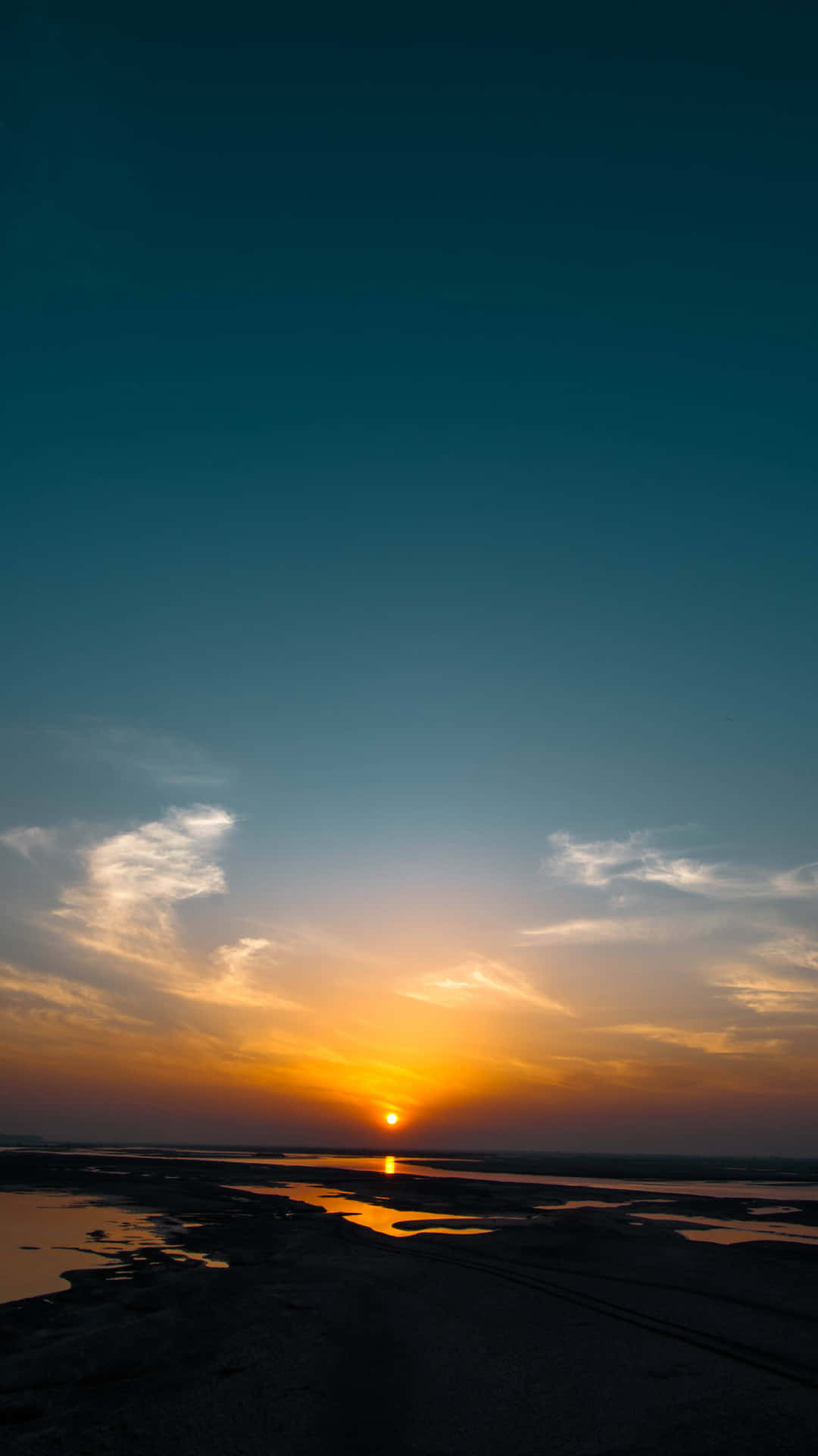 A Sunset Over A Beach With Water And A Boat Background