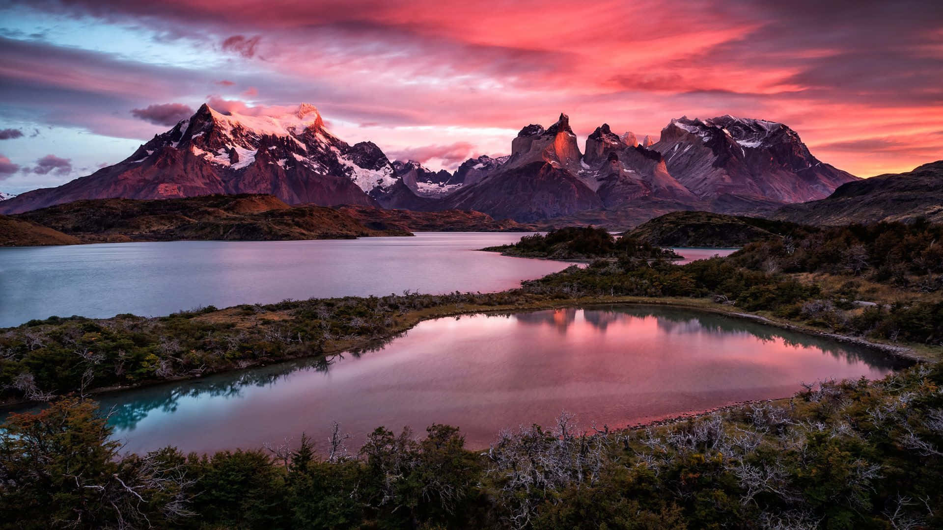 A Sunset Over A Lake And Mountains Background
