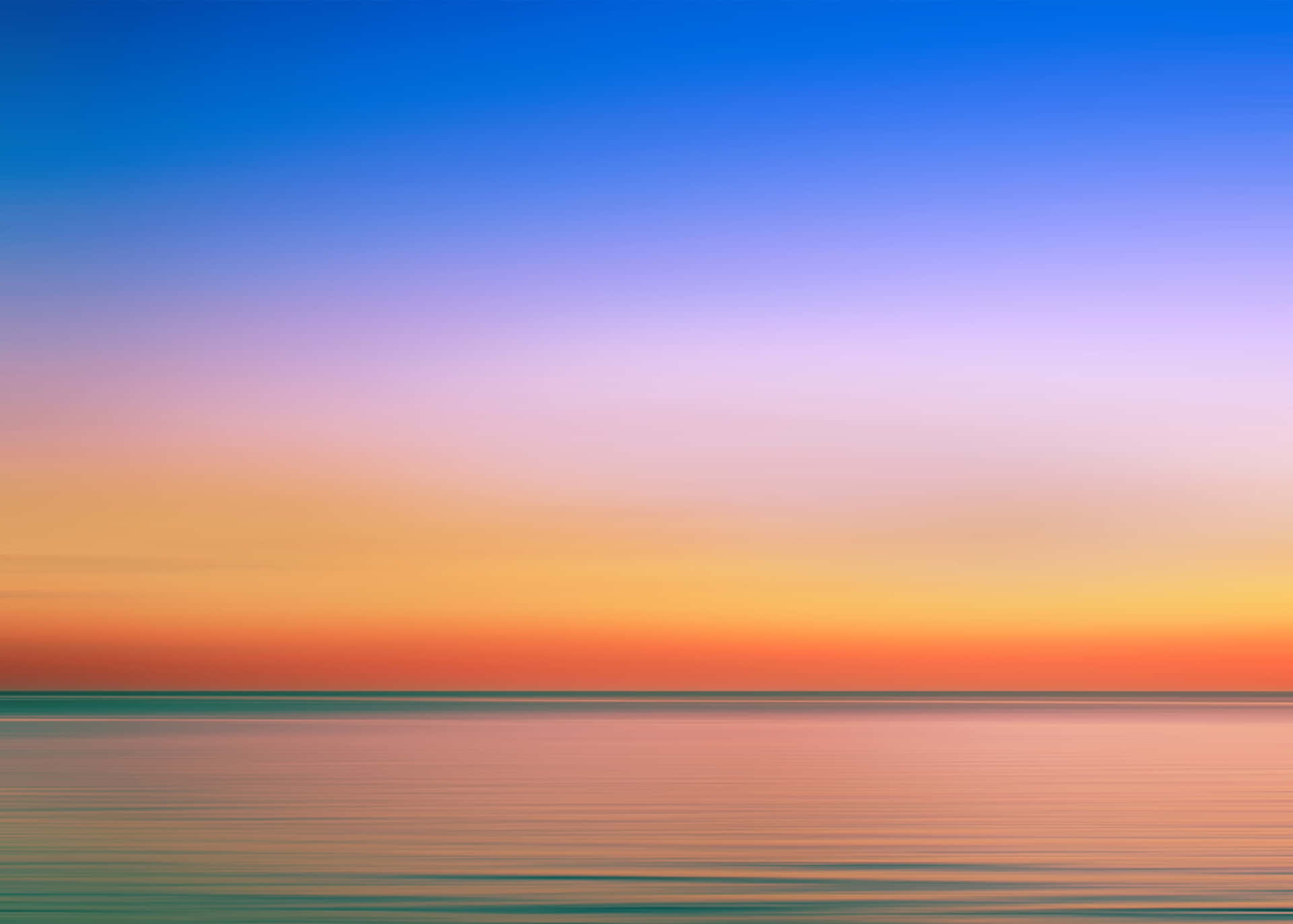 A Sunset Over The Ocean With A Colorful Sky