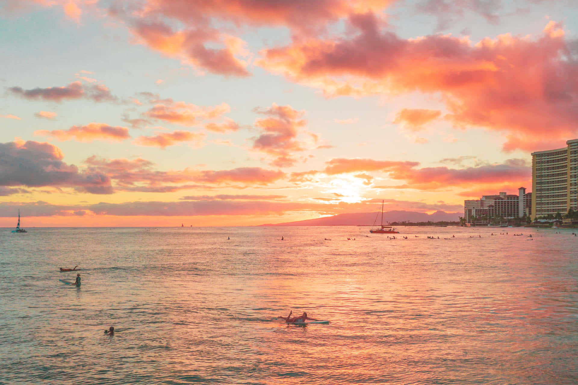 A Sunset Over The Ocean With People In The Water Background