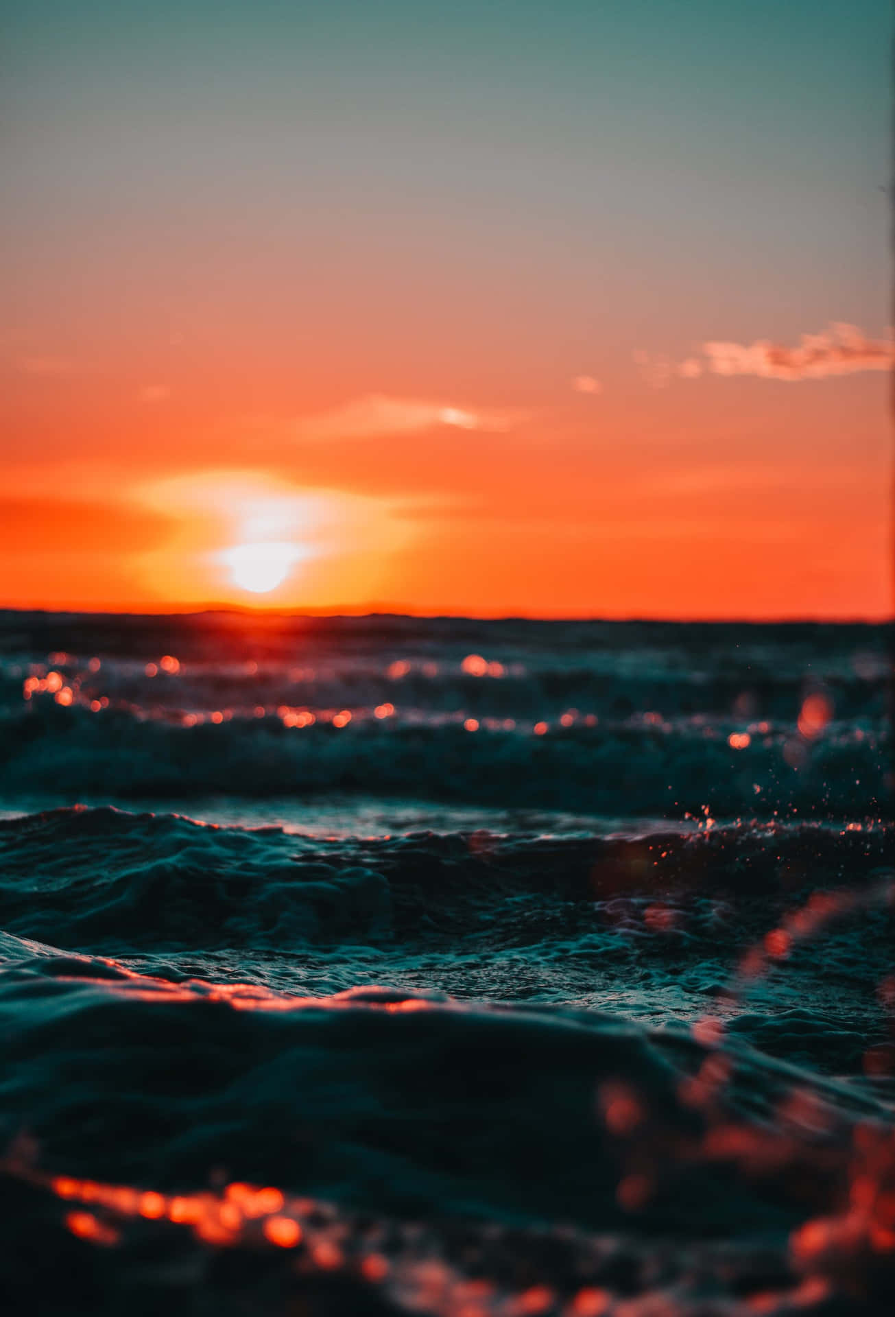 A Sunset Over The Ocean With Waves