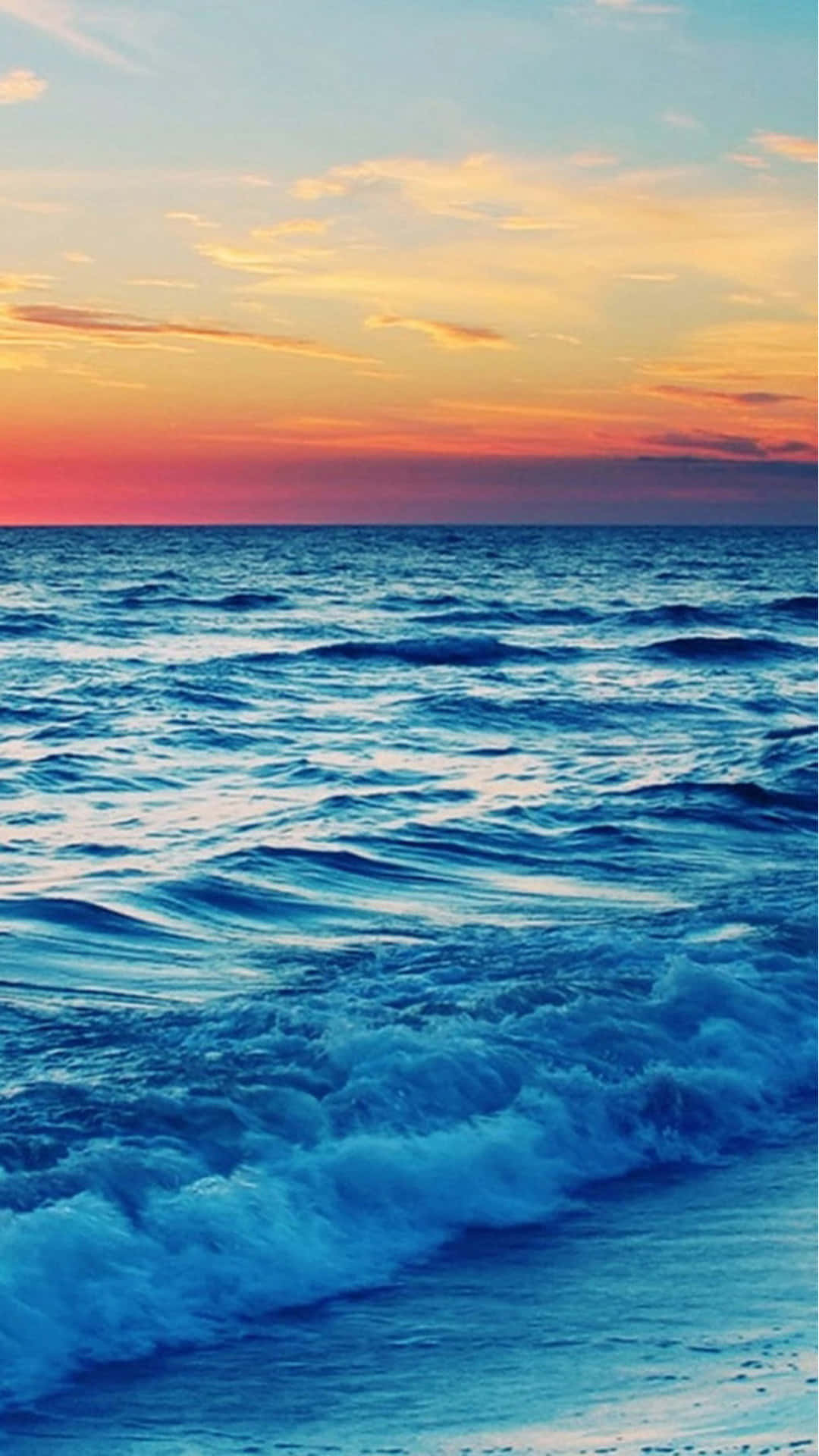 A Sunset Over The Ocean With Waves