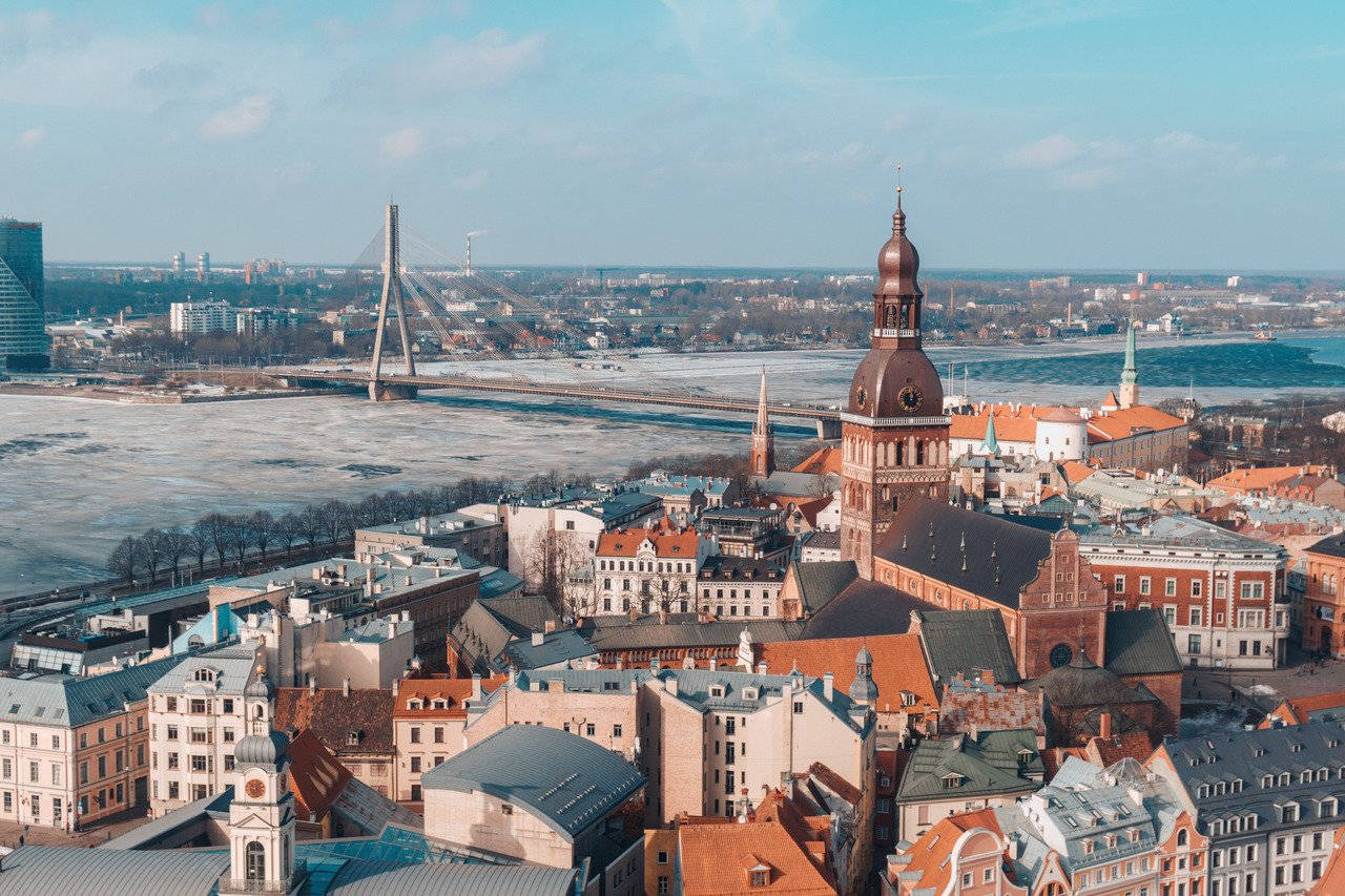 A Sunset View Of The Riga City Skyline Background