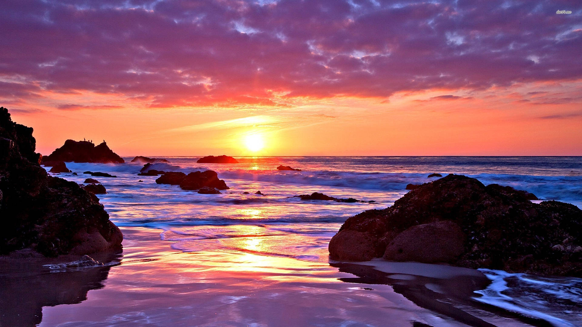 A Sunset With Rocks And Water Background