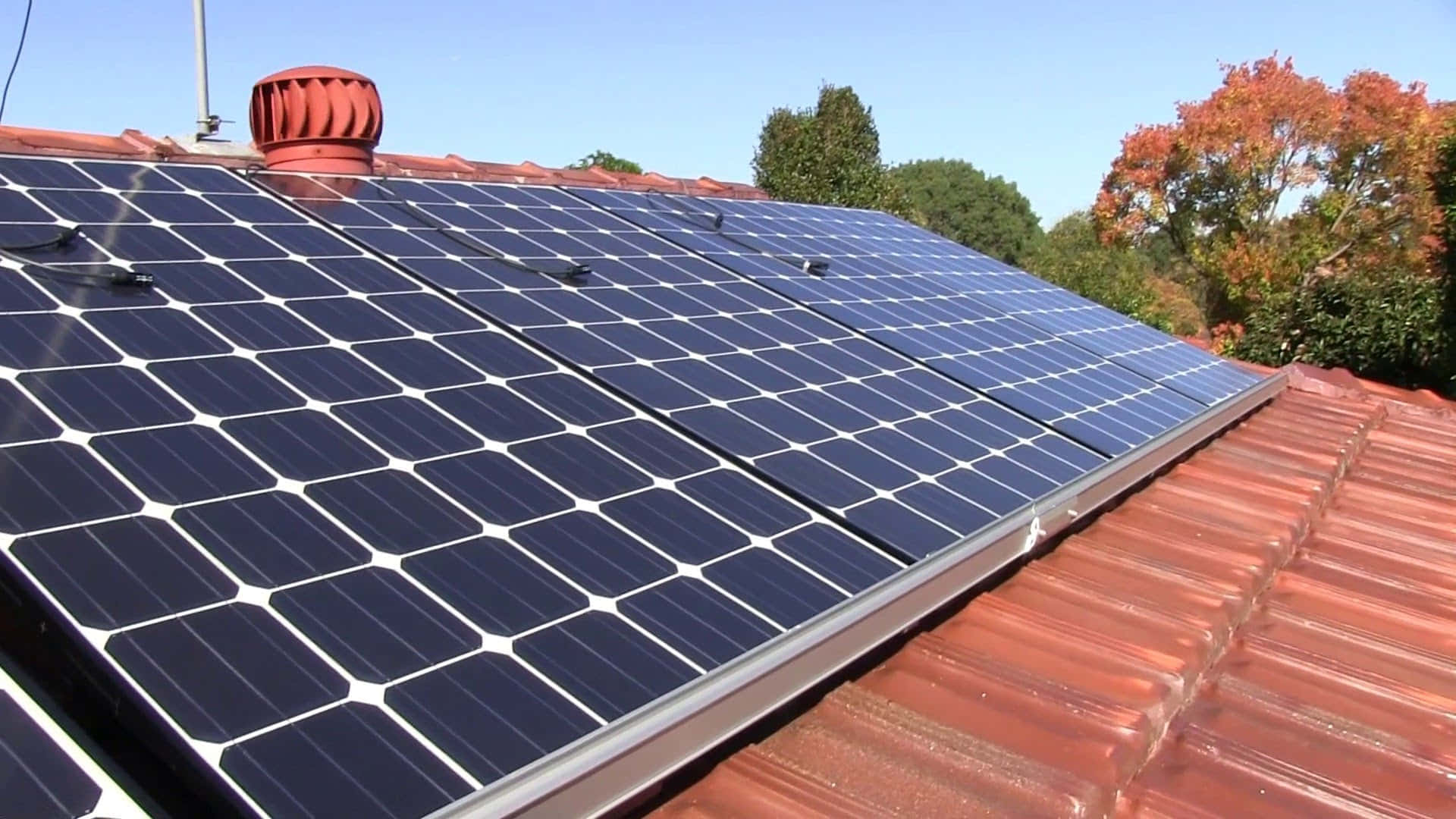 A Sustainable House With Solar Panels On The Brown Roof Background