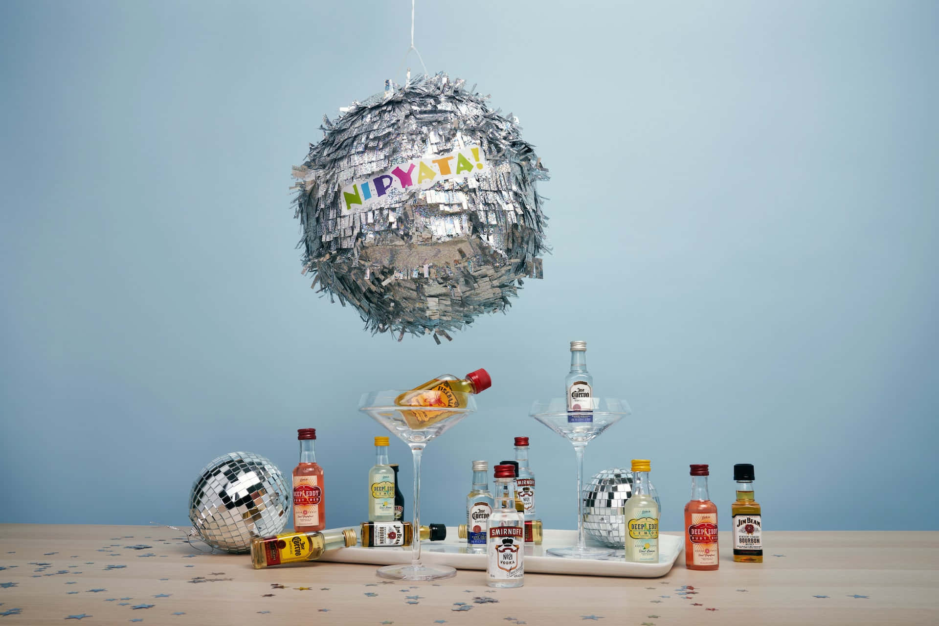 A Table With A Pinata Hanging From It And A Bottle Of Liquor Background