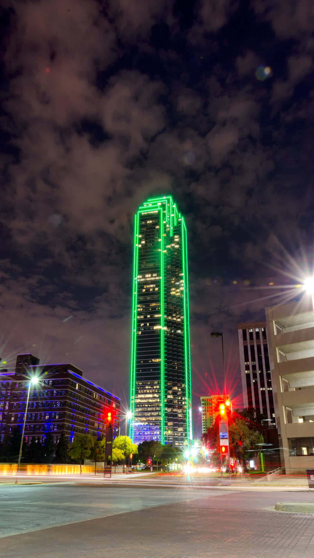A Tall Building With Green Lights