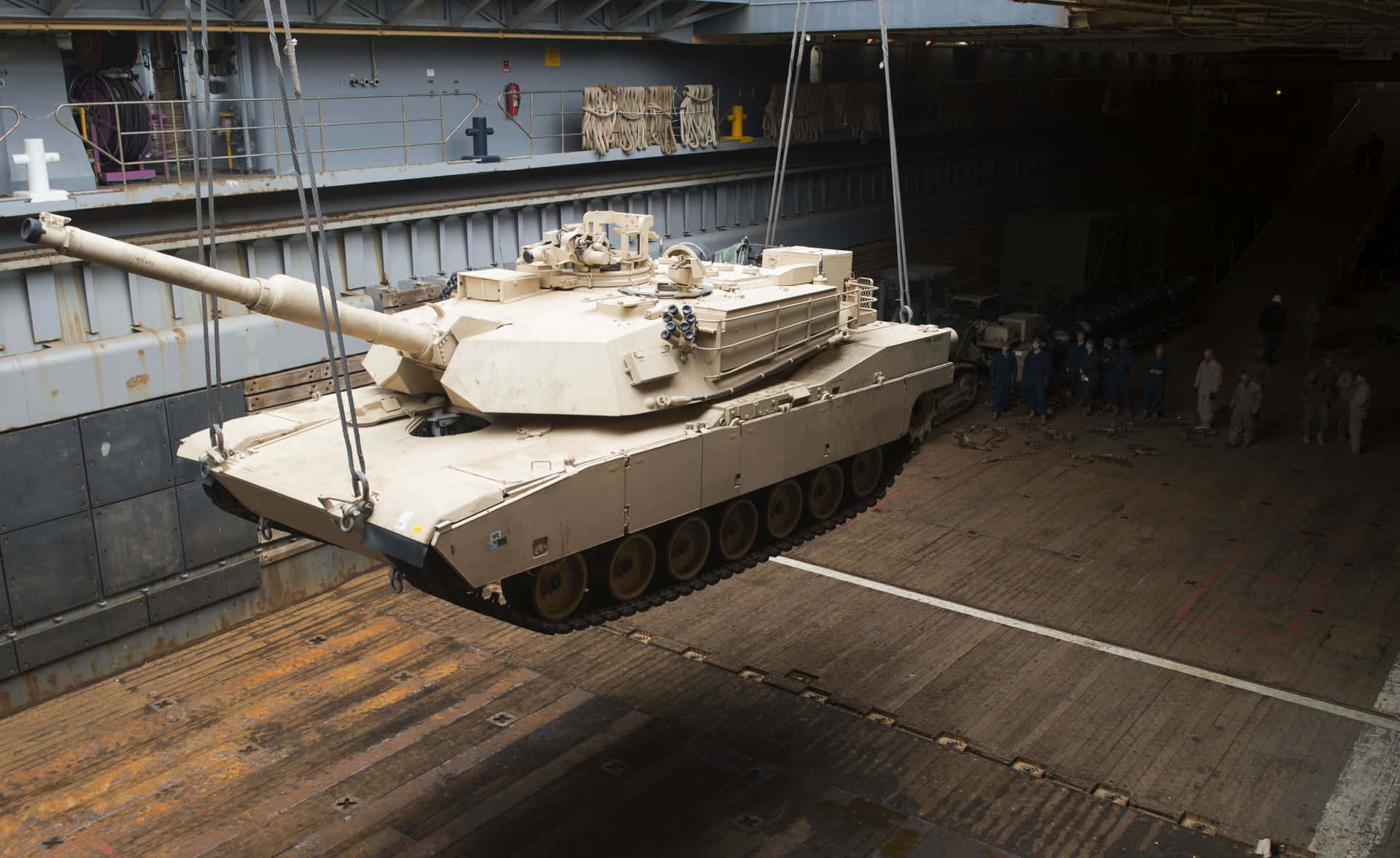 A Tank Is Hanging From A Ship Background