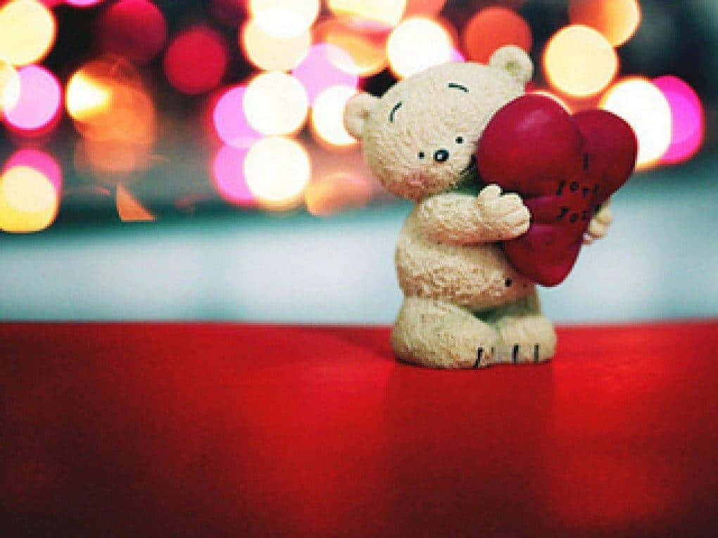 A Teddy Bear Holding A Heart Background