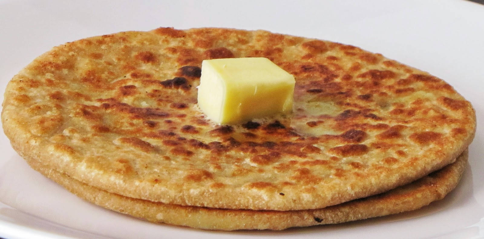 A Tempting Slice Of Flatbread Generously Spread With Butter