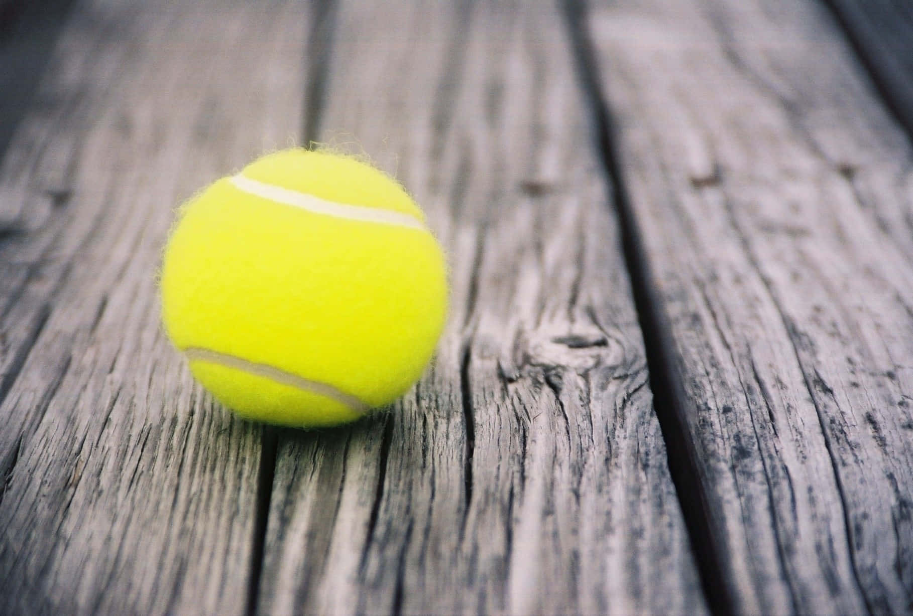 A Tennis Ball On A Wooden Surface Background