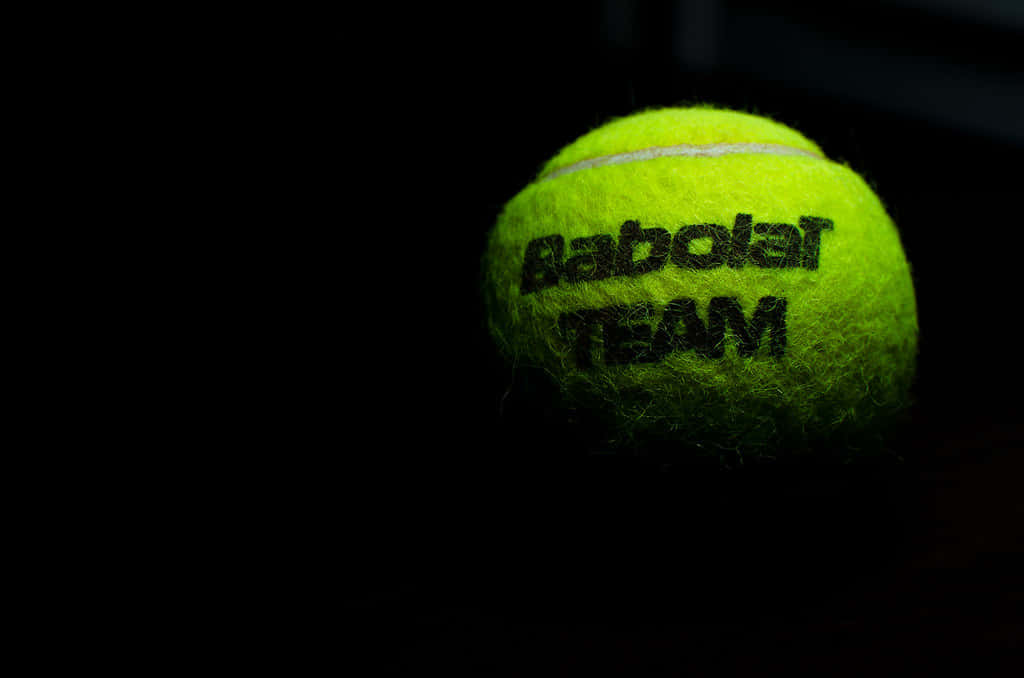 A Tennis Ball With The Word Baboler Team On It Background