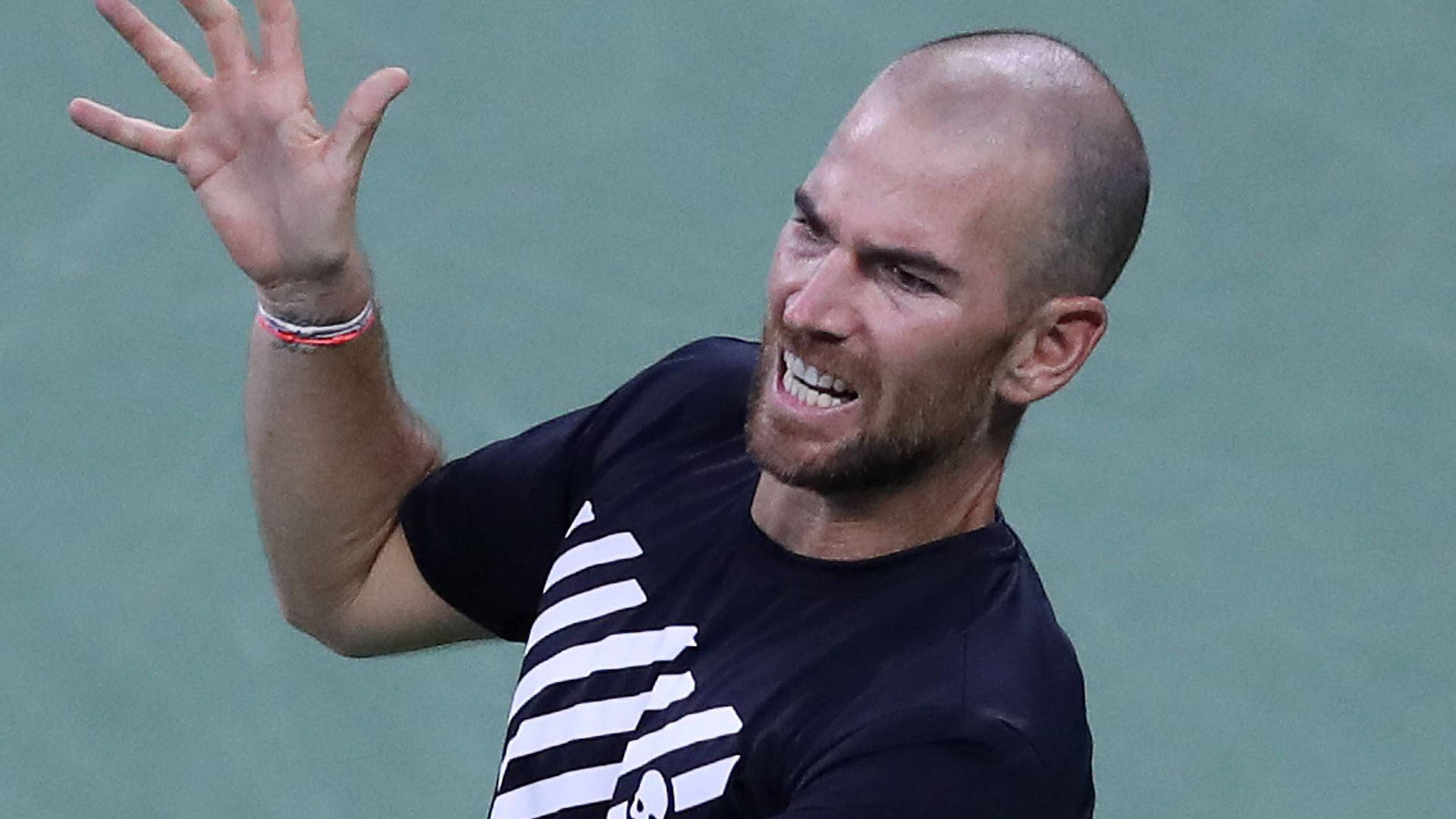 A Tennis Player Is Holding His Racket Up Background