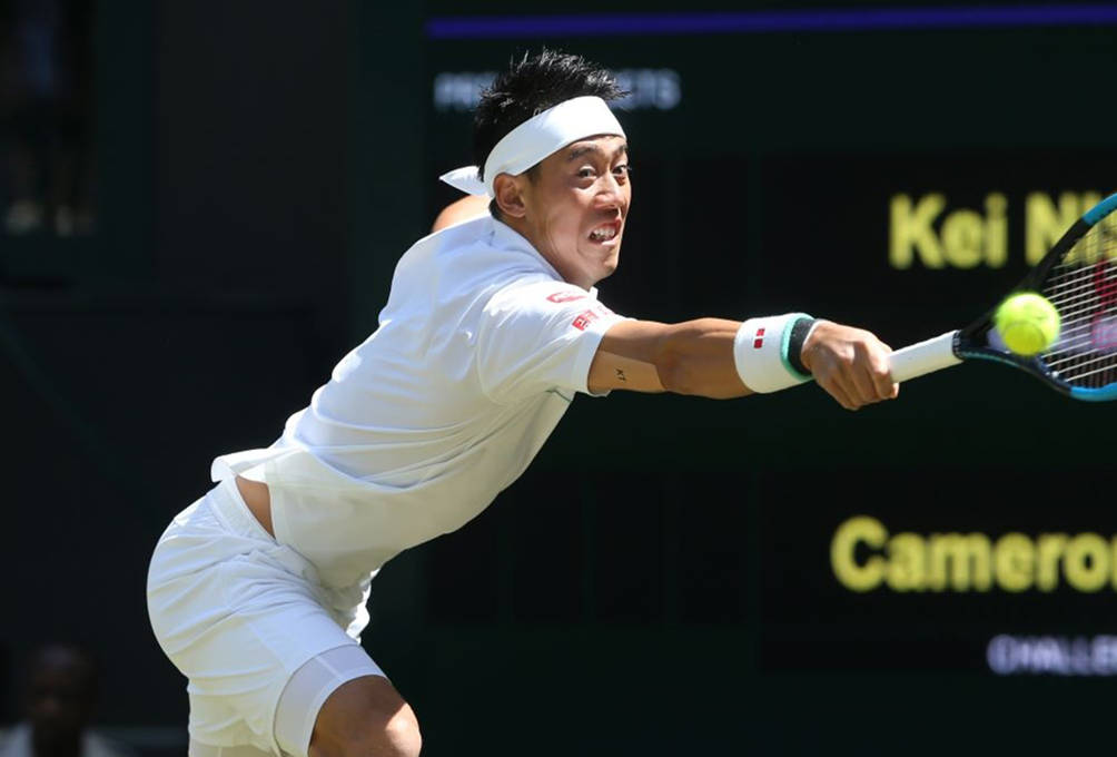 A Tennis Player Is Swinging His Racket At A Ball