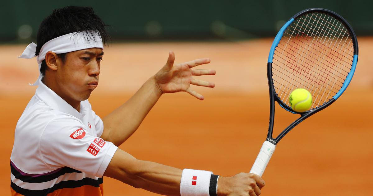 A Tennis Player Is Swinging His Racket At A Ball