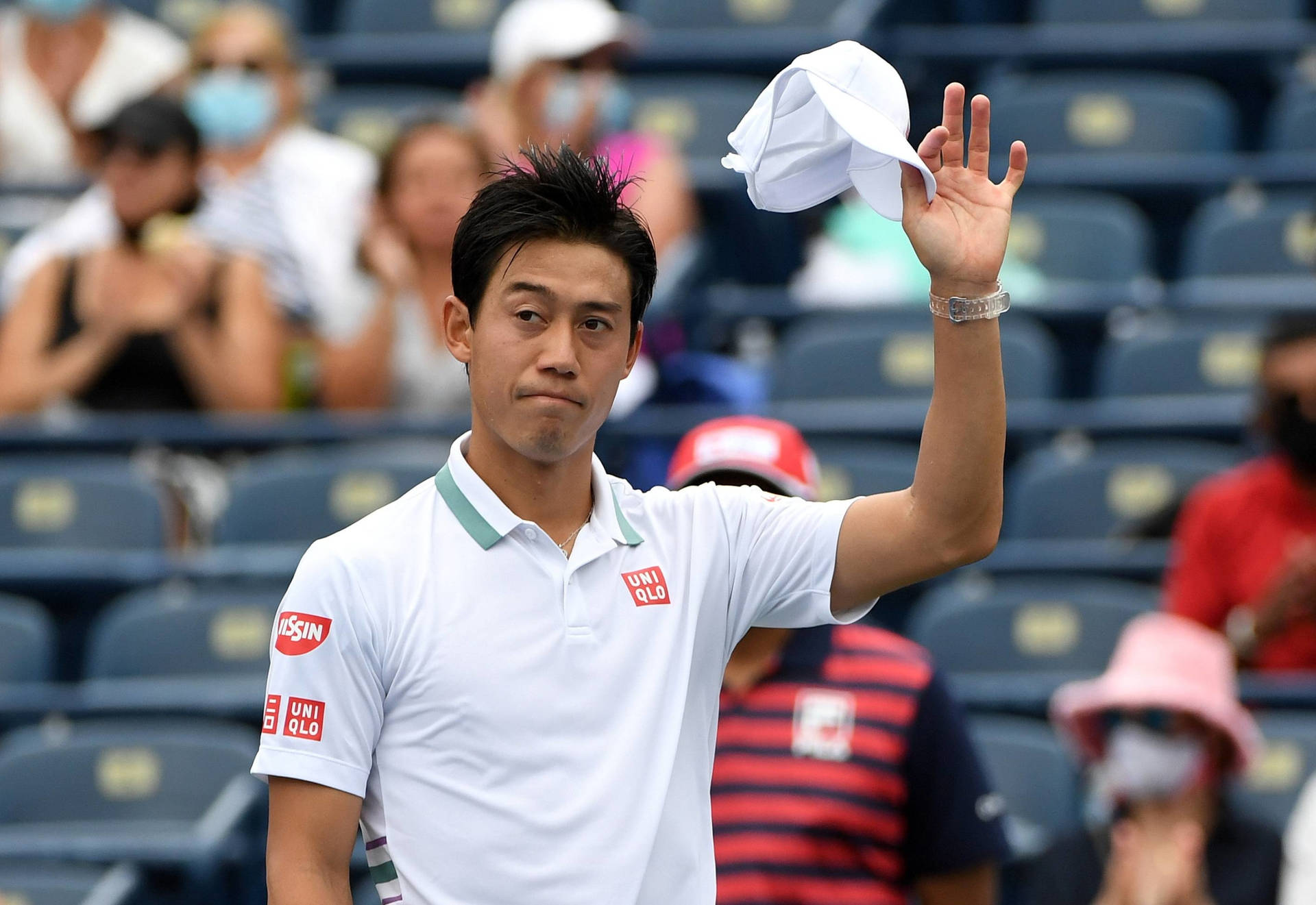 A Tennis Player Is Waving His Hat To The Crowd Background