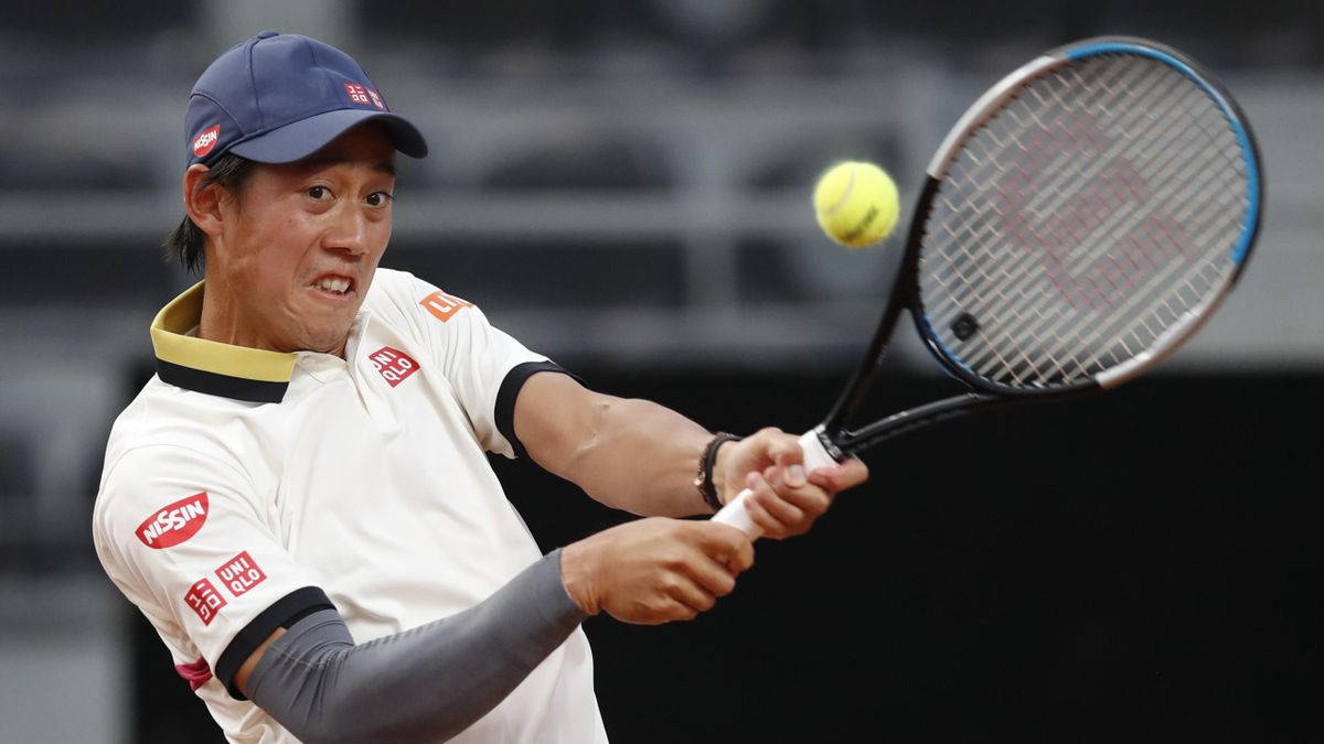 A Tennis Player Swinging His Racket At A Ball