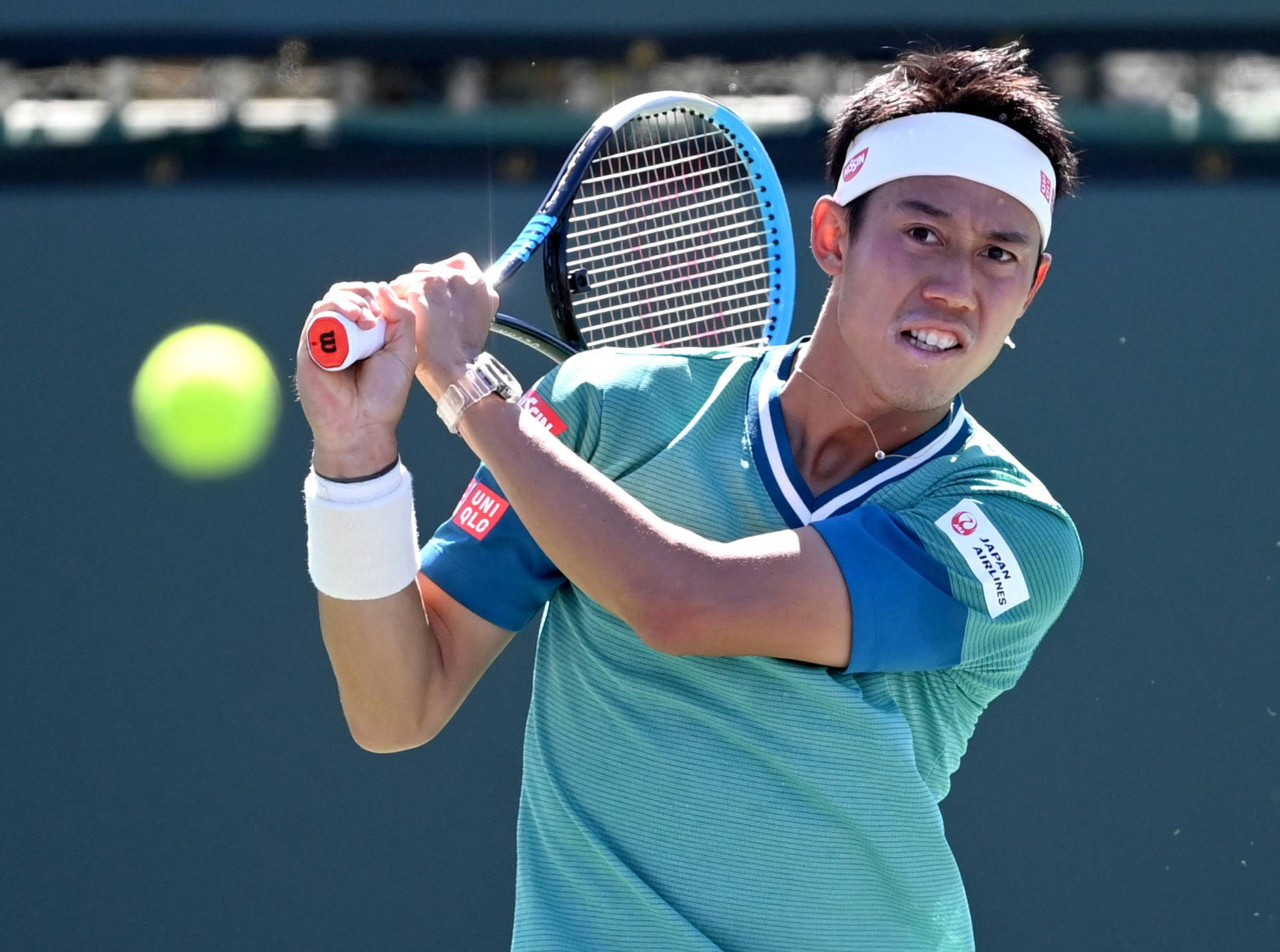 A Tennis Player Swinging His Racket At A Ball