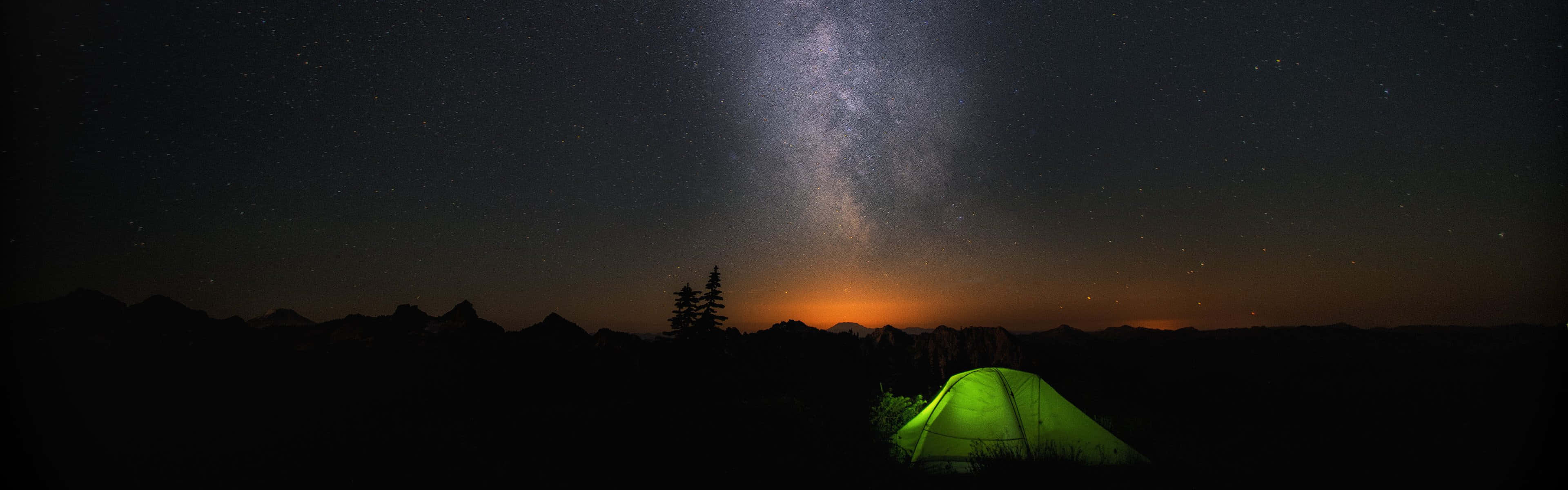 A Tent Is Lit Up Under The Milky Background