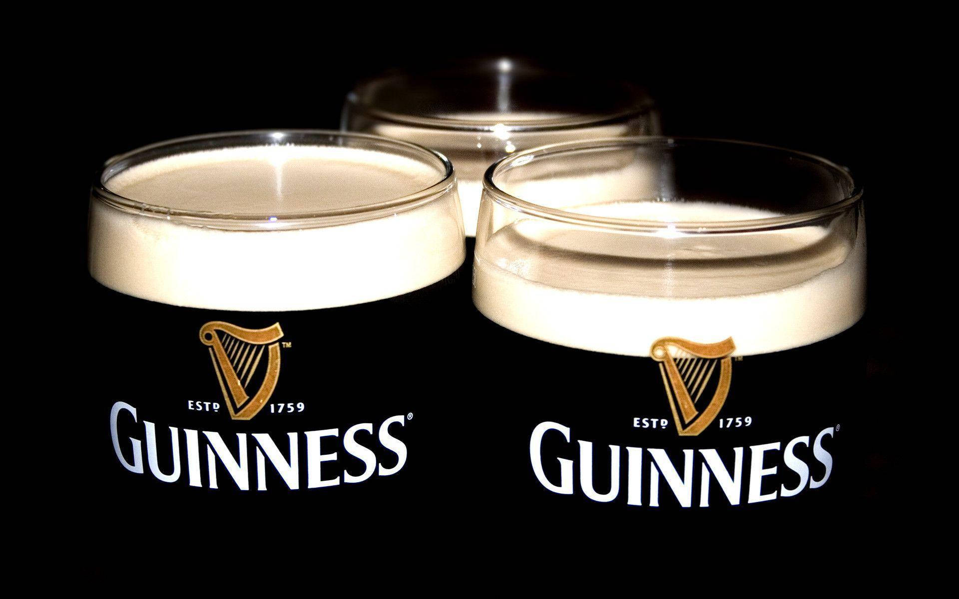 A Toast To Tradition: Three Glasses Of Smooth Guinness Stout Background