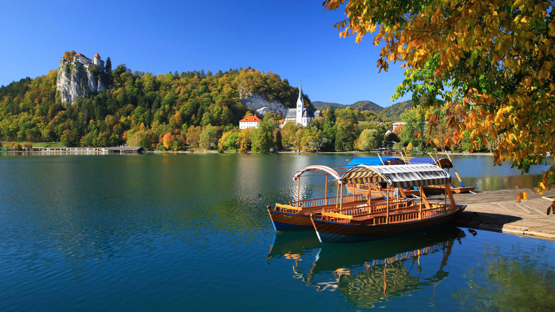 A Tour Boat Docked At Lake Bled Background