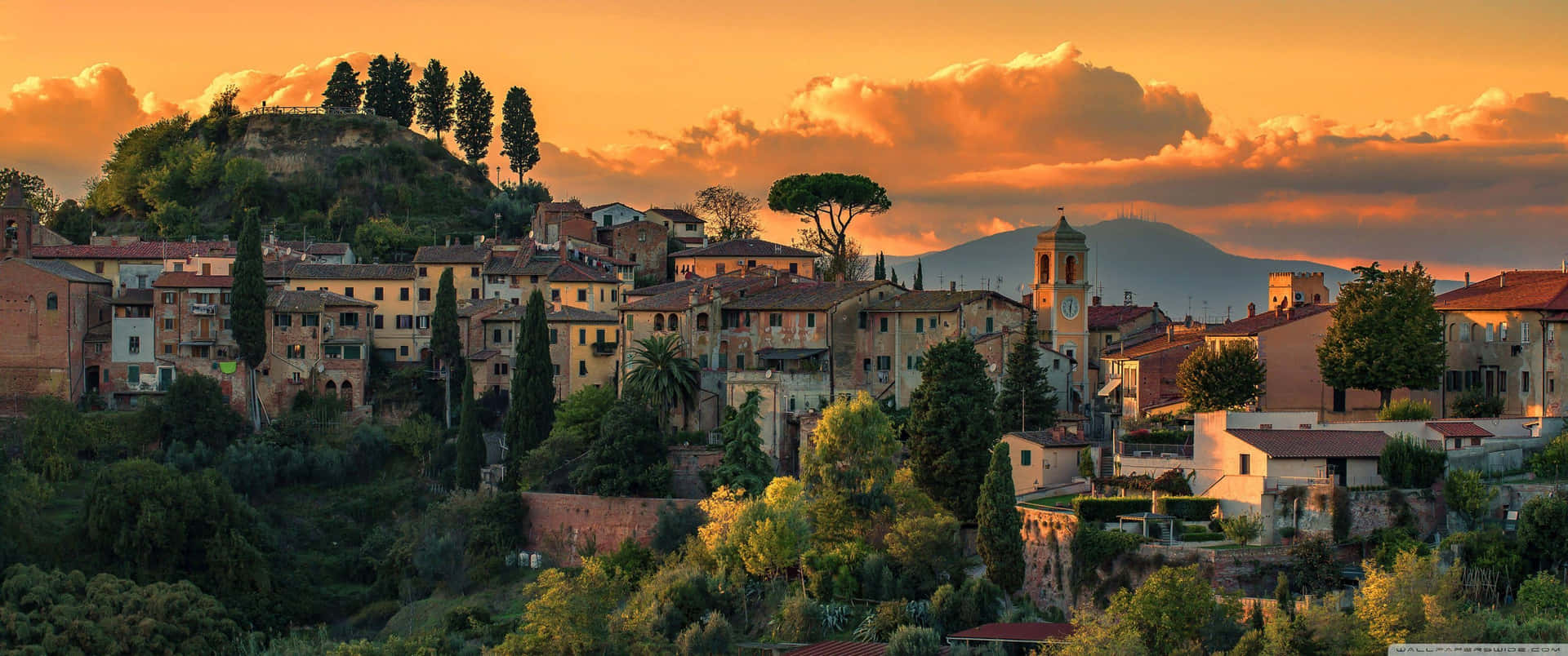 A Town Is Seen At Sunset In Italy Background