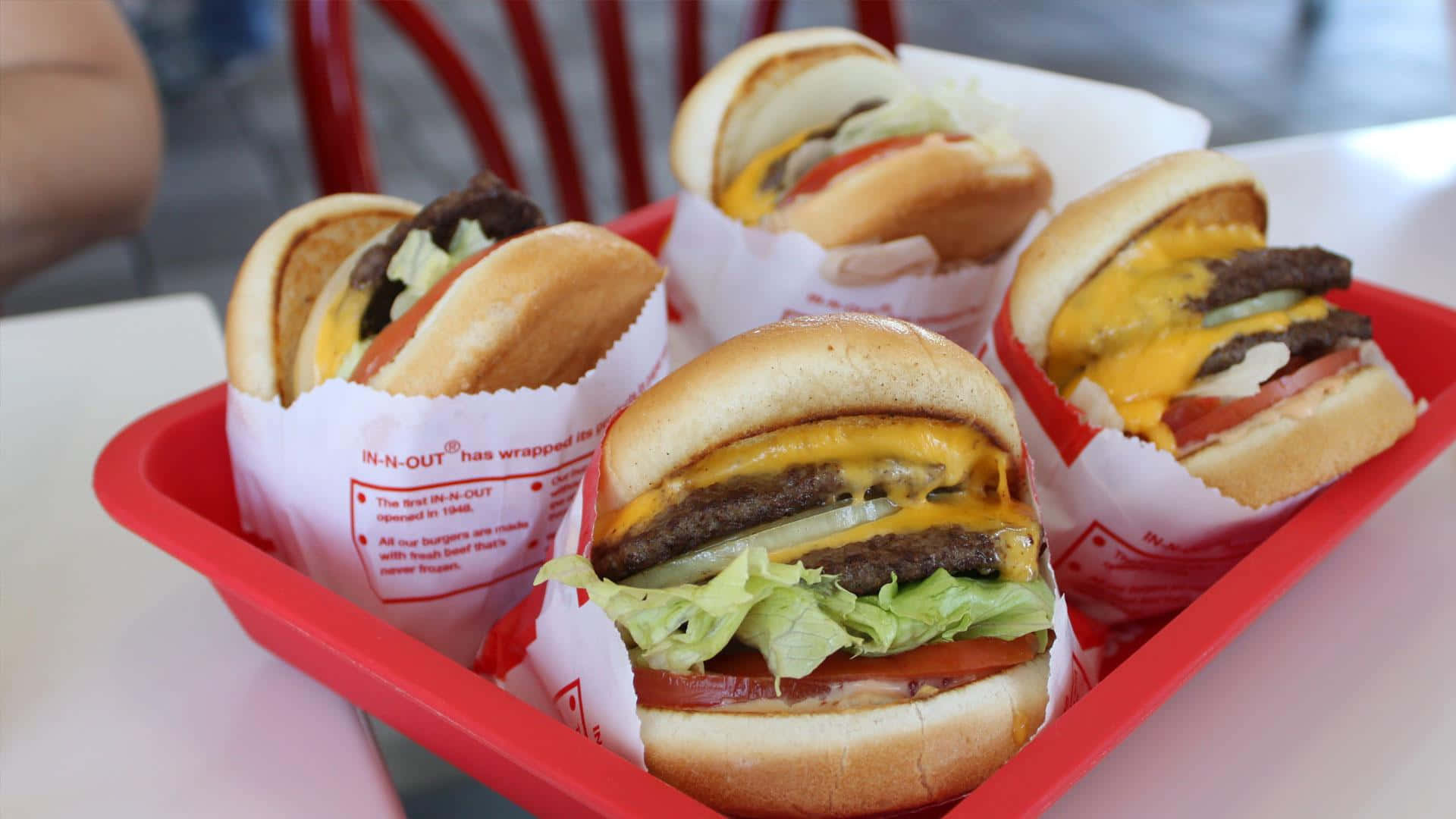 A Tray Of Hamburgers In A Red Basket Background