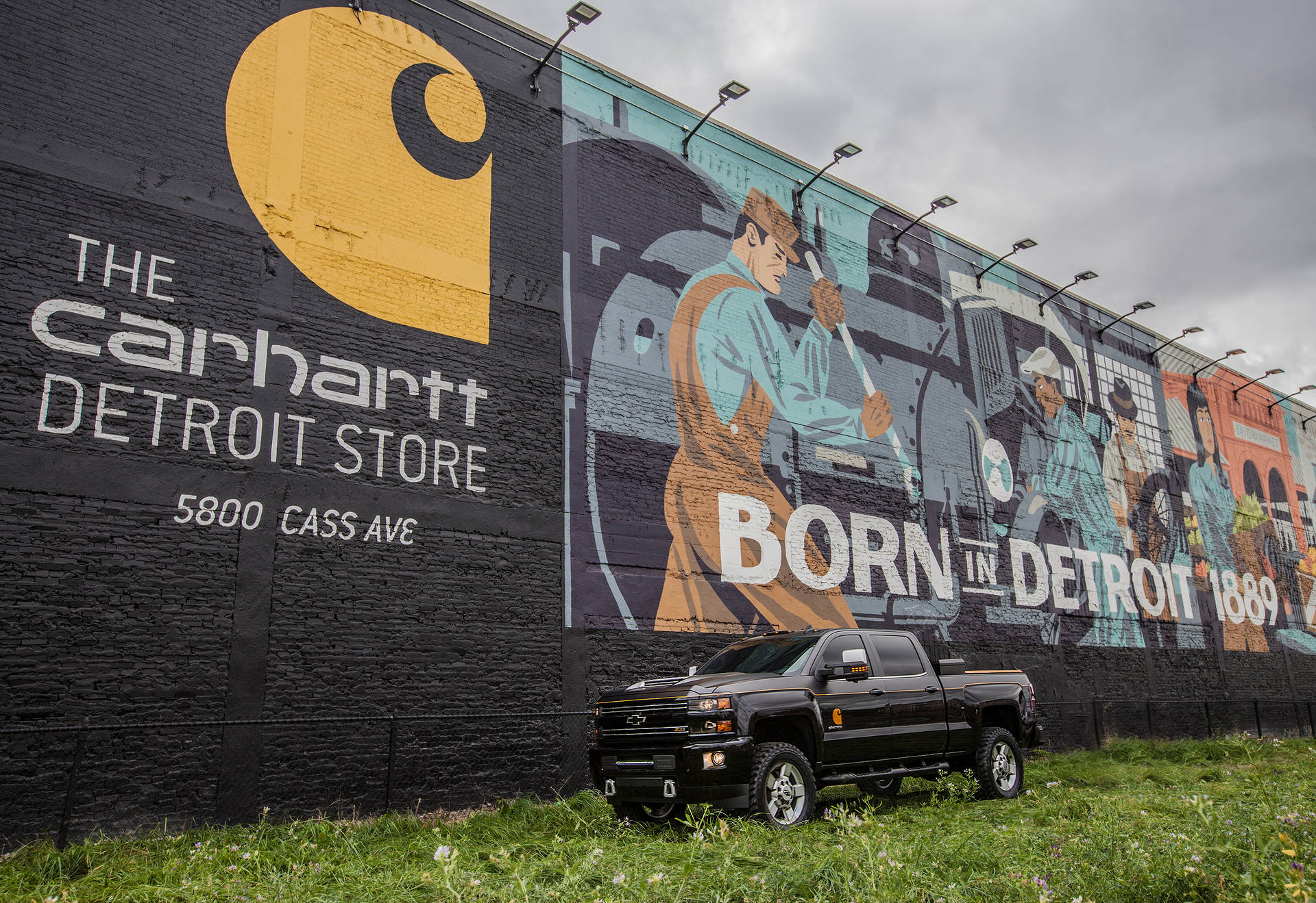 A Truck Parked In Front Of A Mural Background