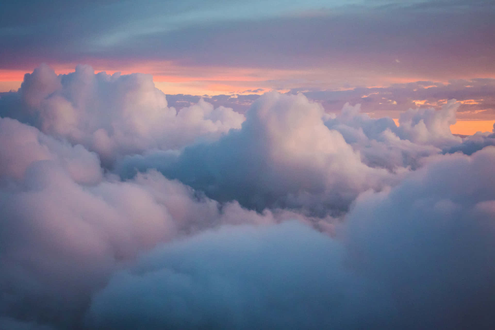 A Vast Sea Of Clouds Cascading Across A Serene Blue Sky. Background