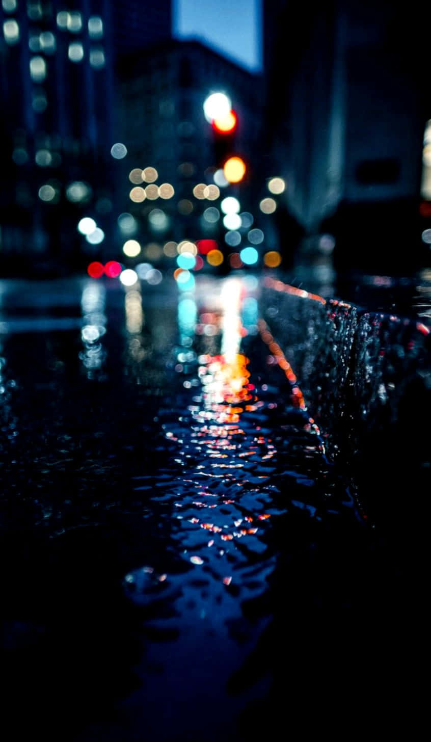 A Vibrant Display Of City Lights Reflected In Rain-soaked Streets At Night. Background